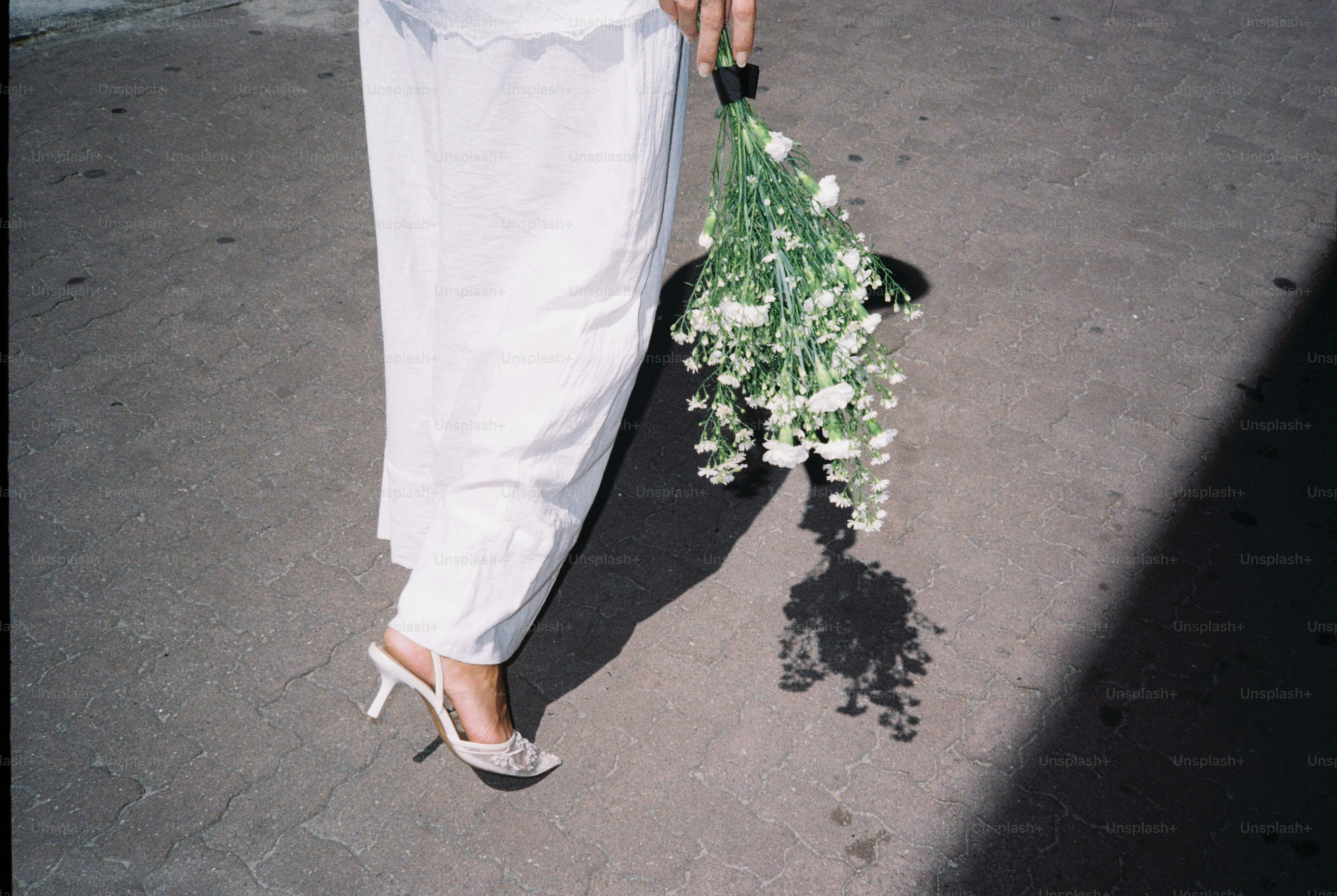 Woman in white dress holding a bouquet of white flowers