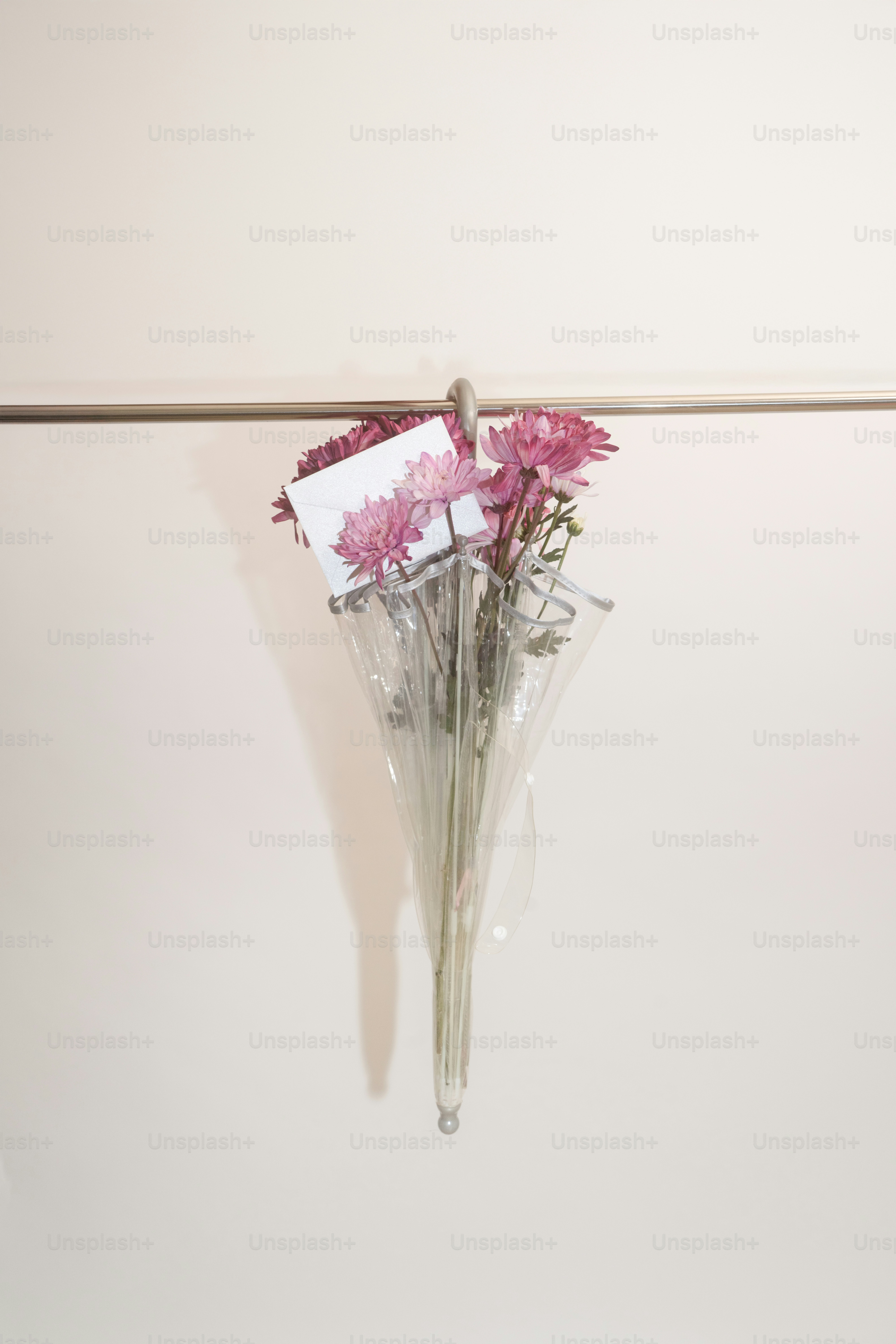 Rosa Blumen in einem durchsichtigen Regenschirm mit einer Karte