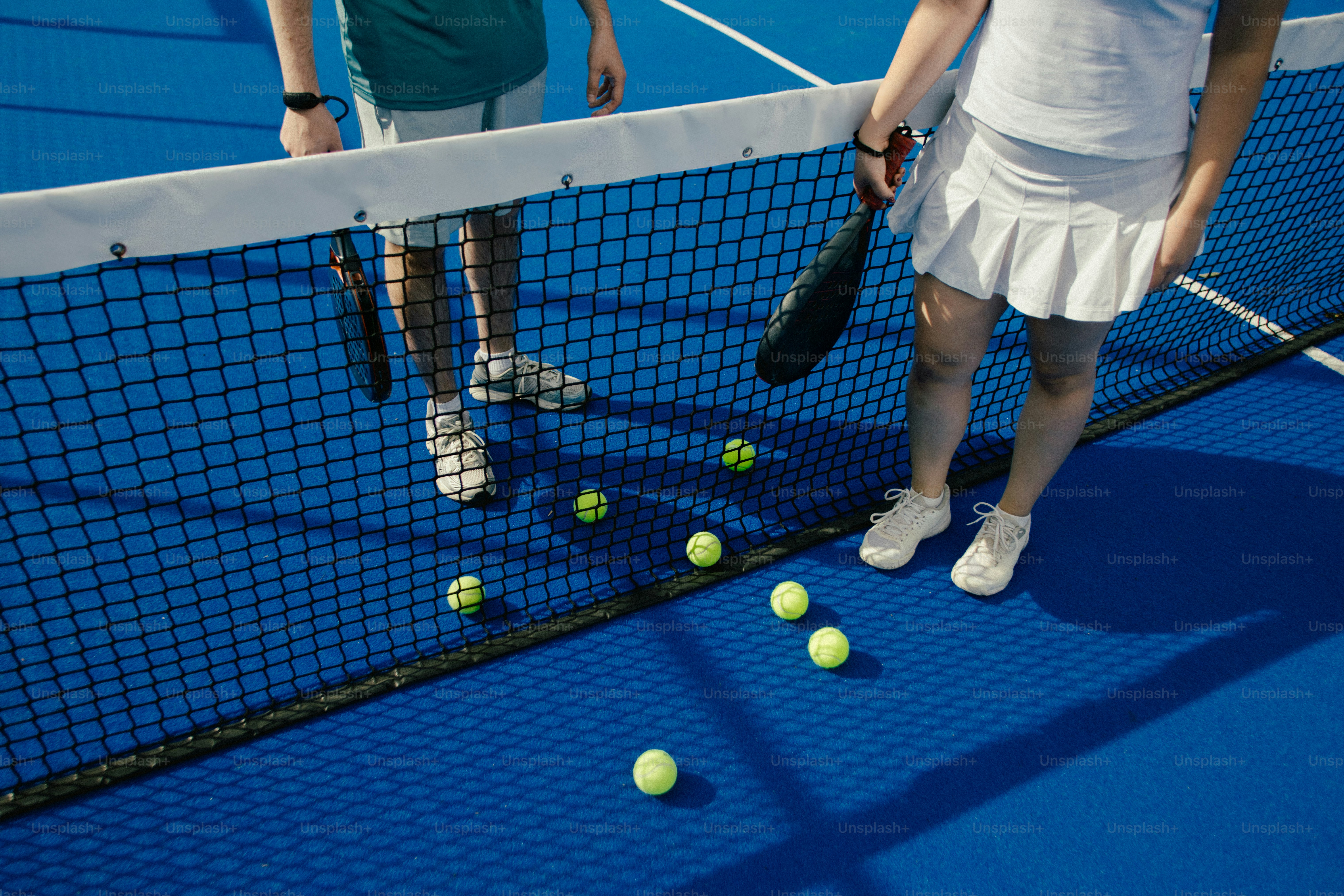 Two people in tennis attire with racquets and balls photo – Fitness ...