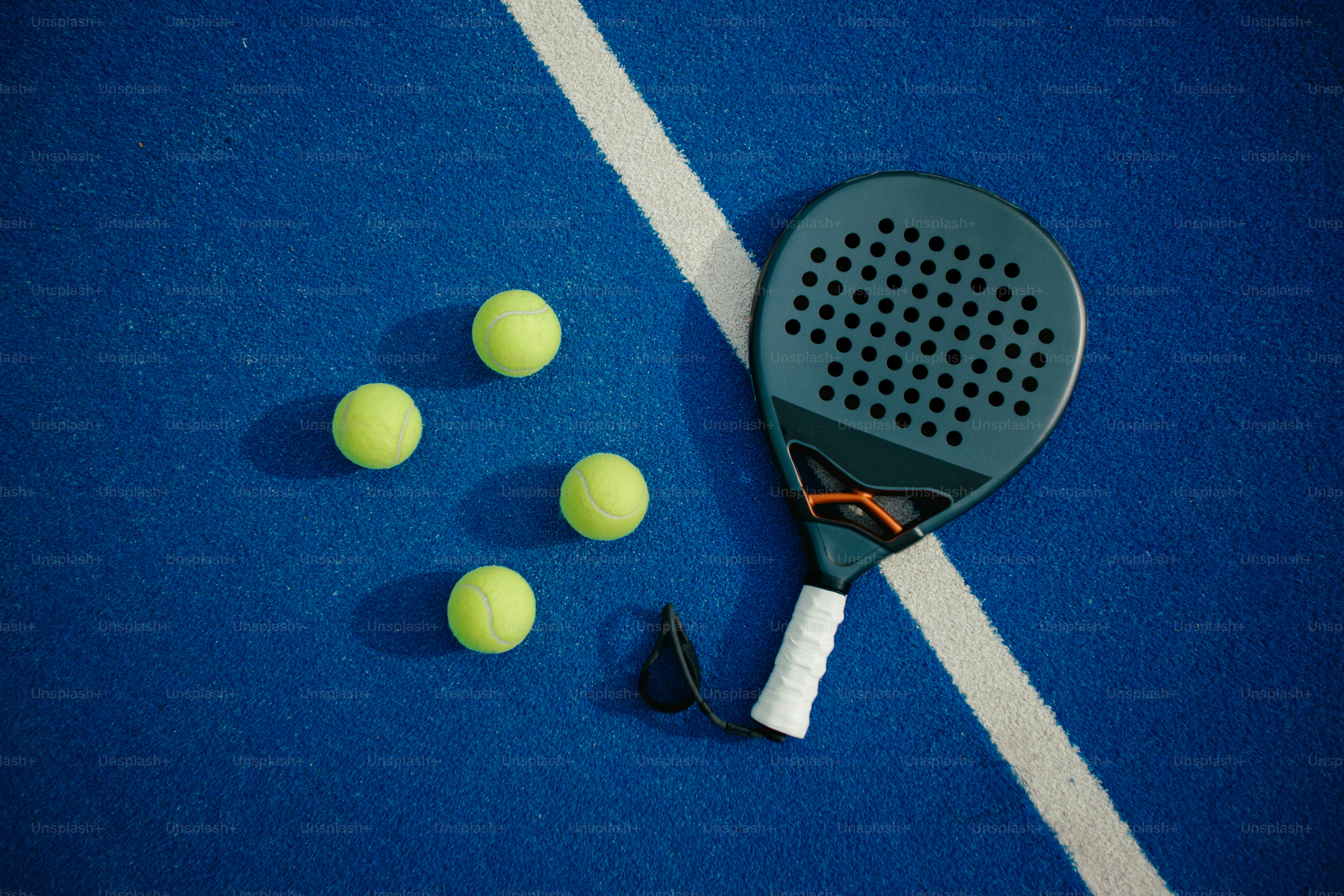 Padel racket and balls on blue court photo – Padel Image on Unsplash