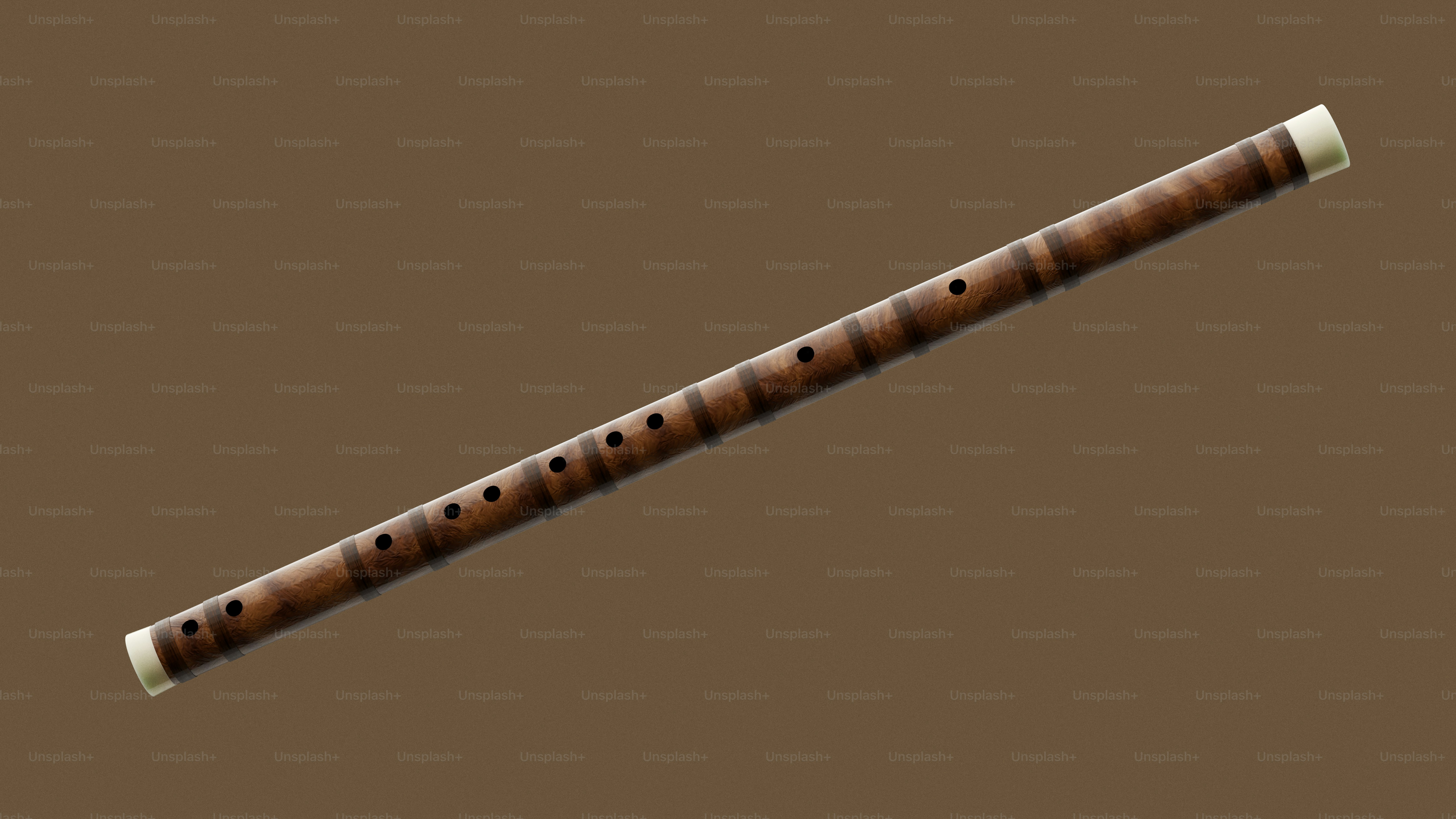 A long wooden flute with white ends rests on brown.