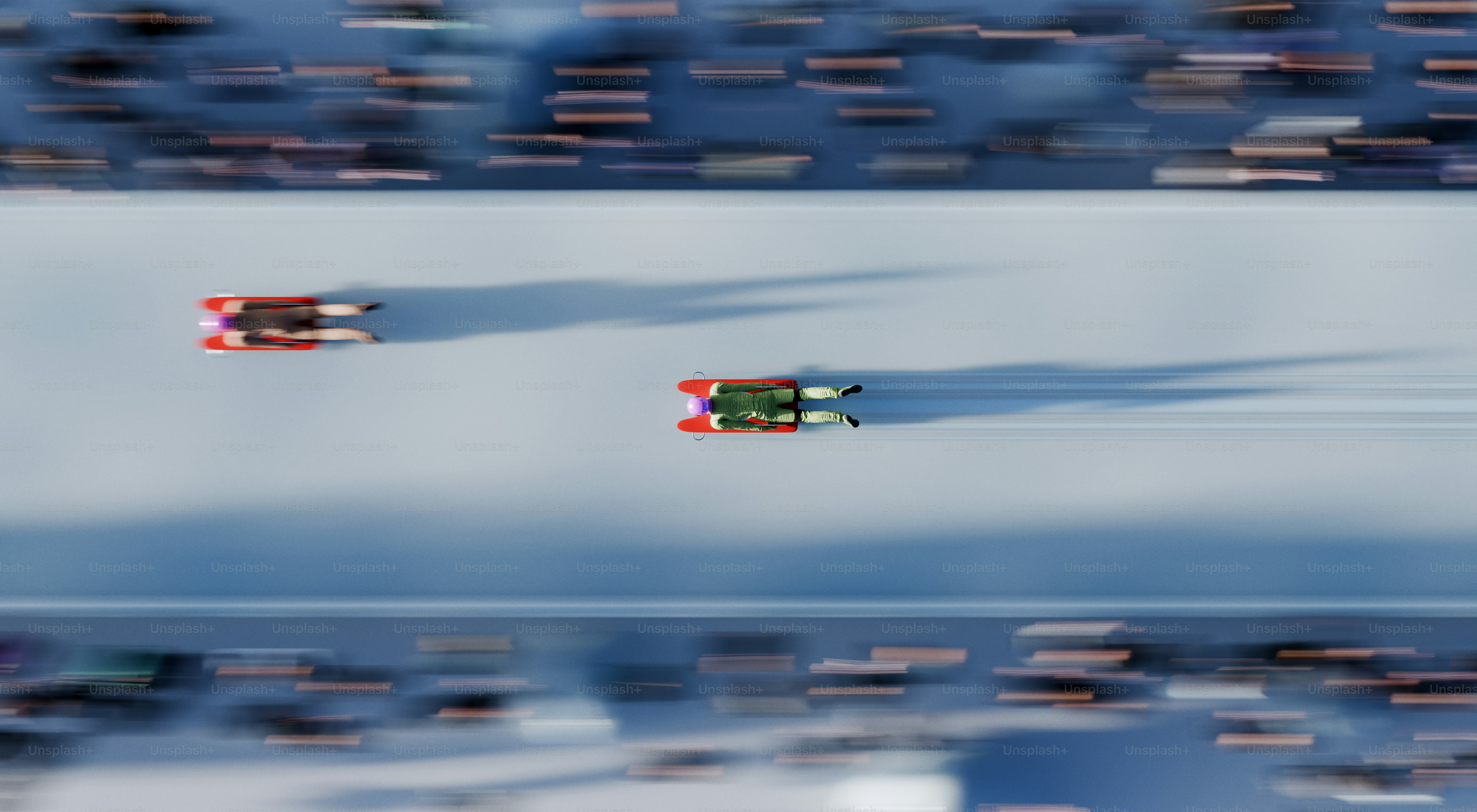 Two bobsleds race down a snowy track.