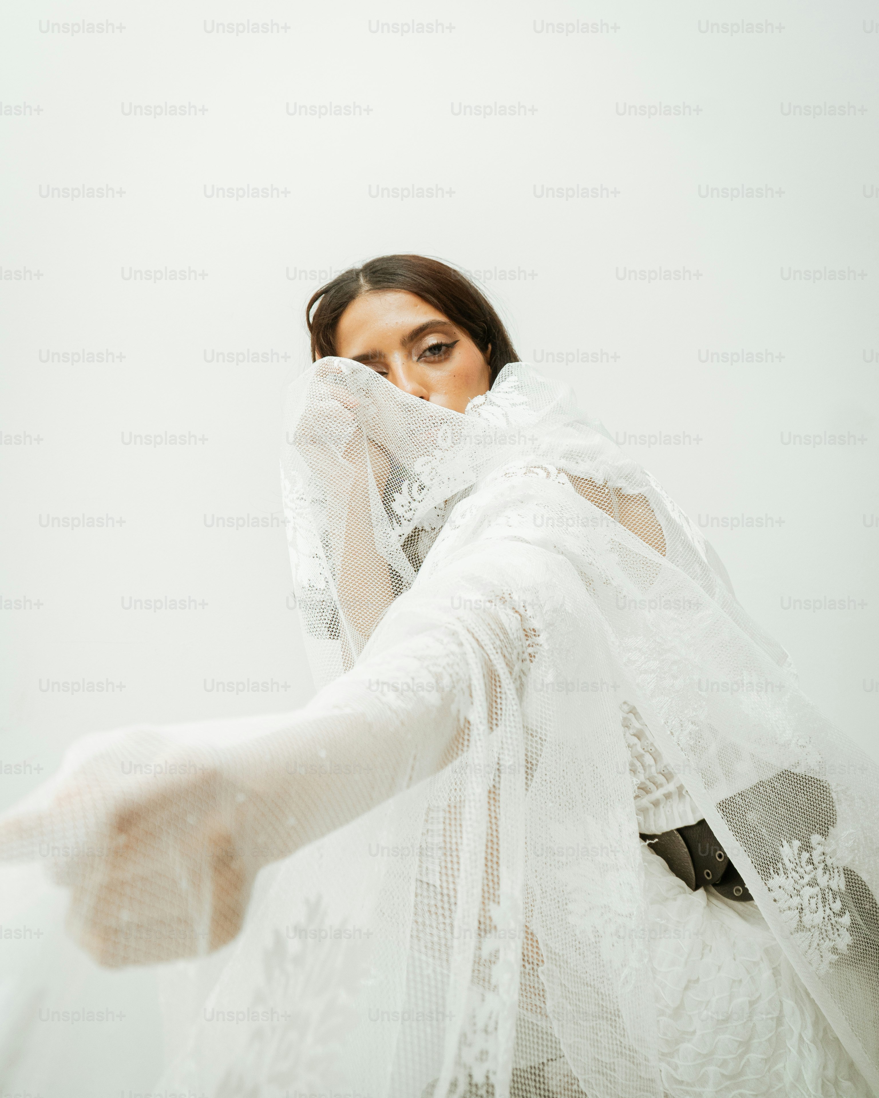 Woman in white lace veil covering face