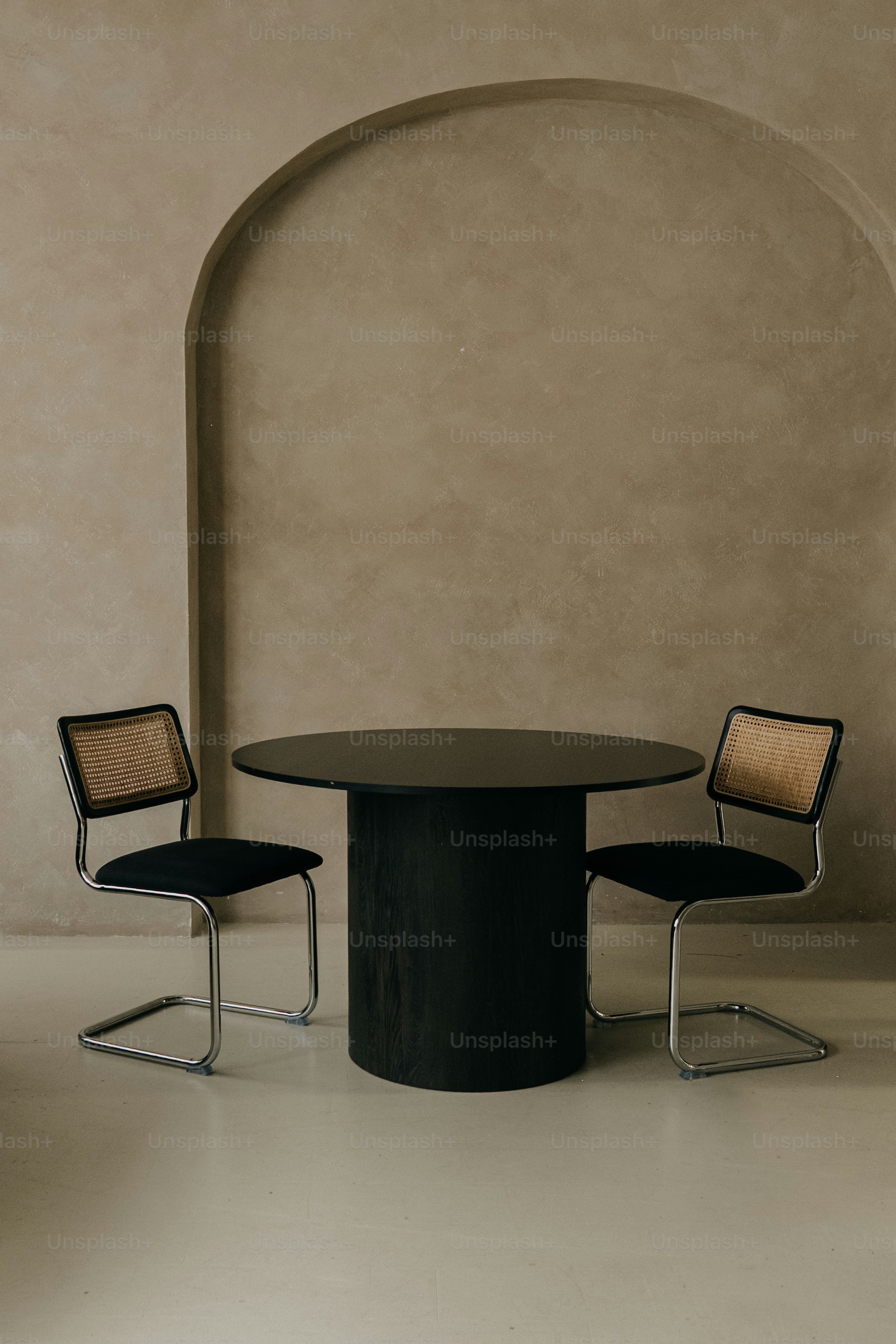 Two chairs and a round table in a room.