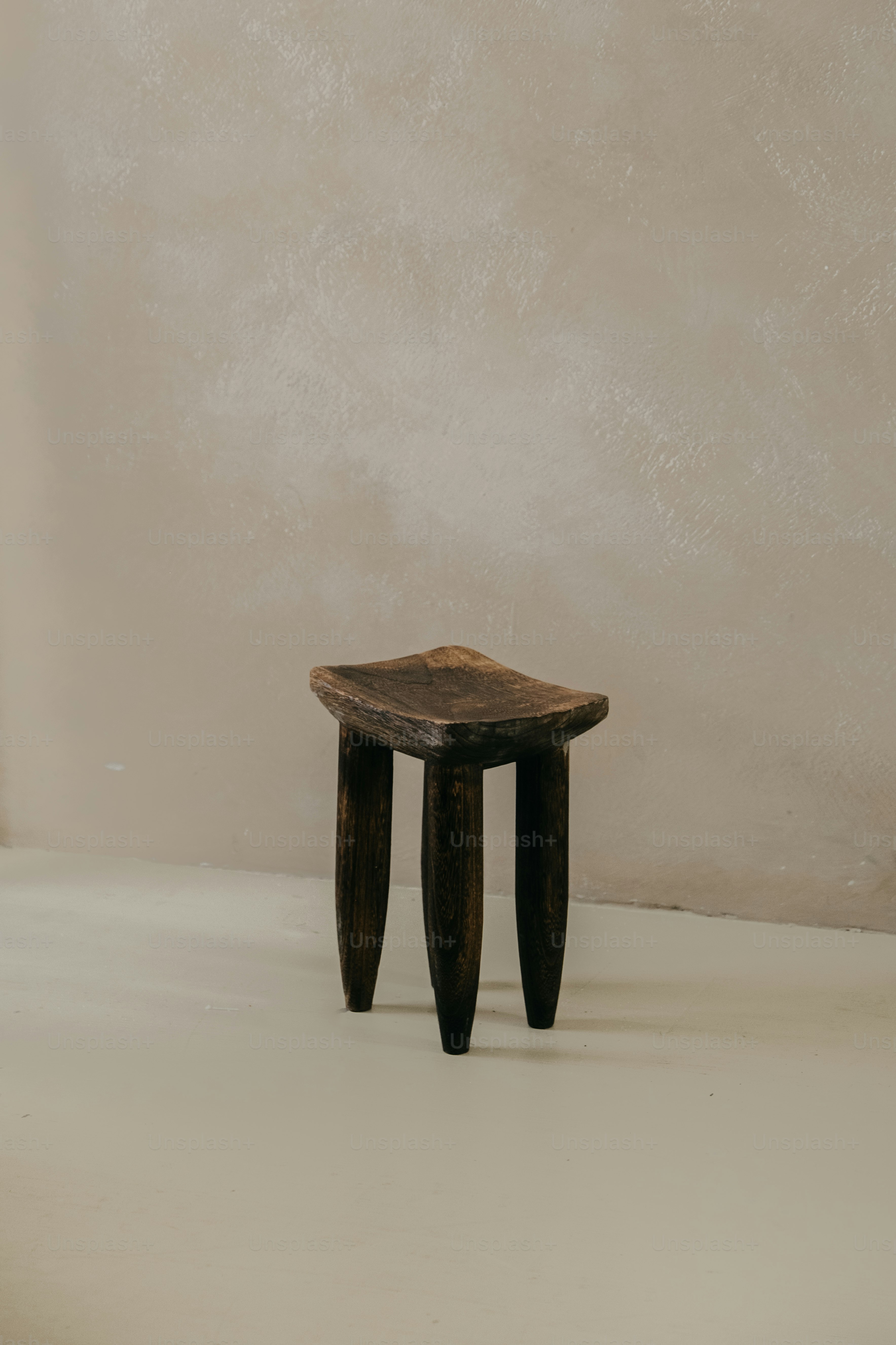 A rustic wooden stool with three legs.