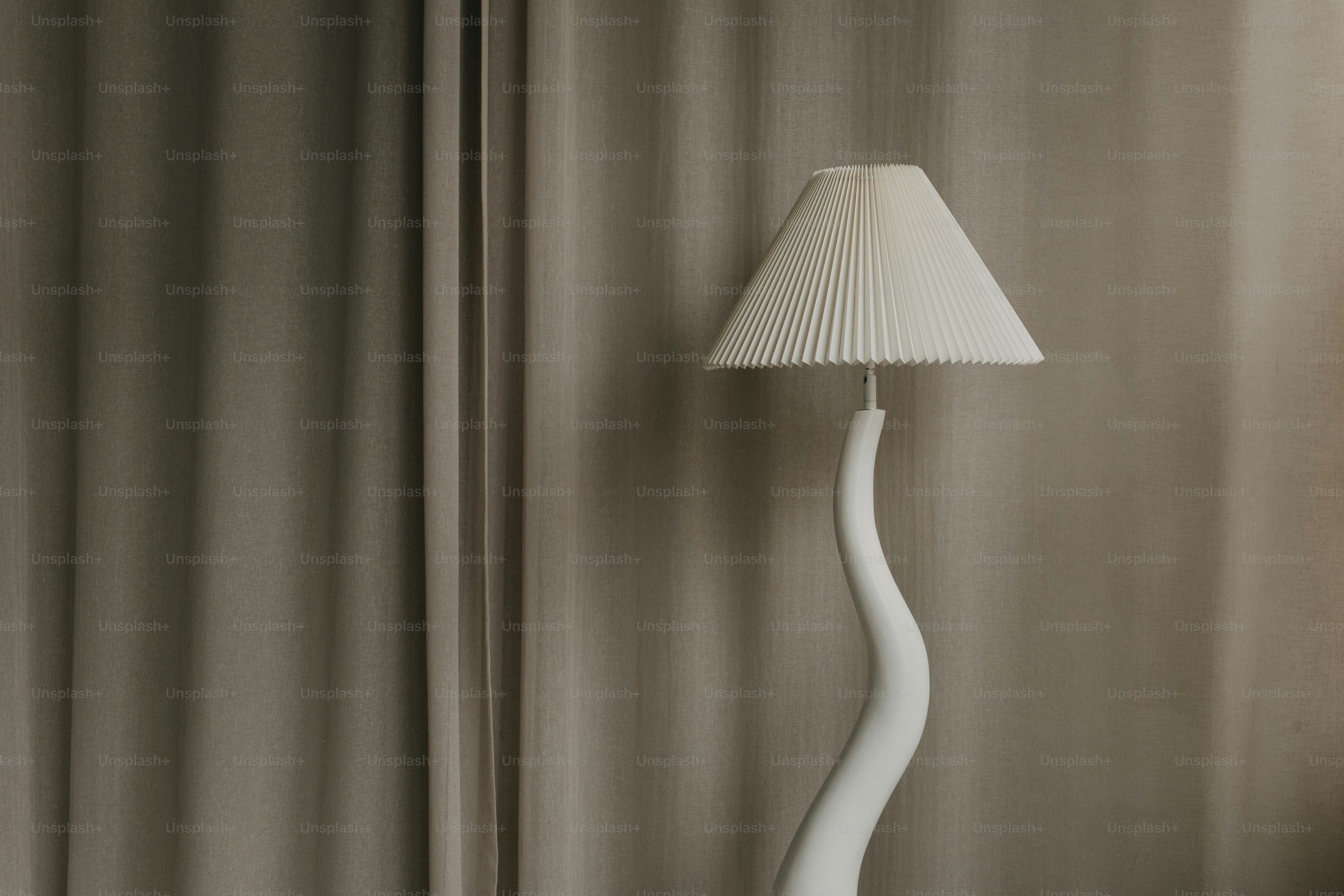 A white lamp with a pleated shade stands tall.