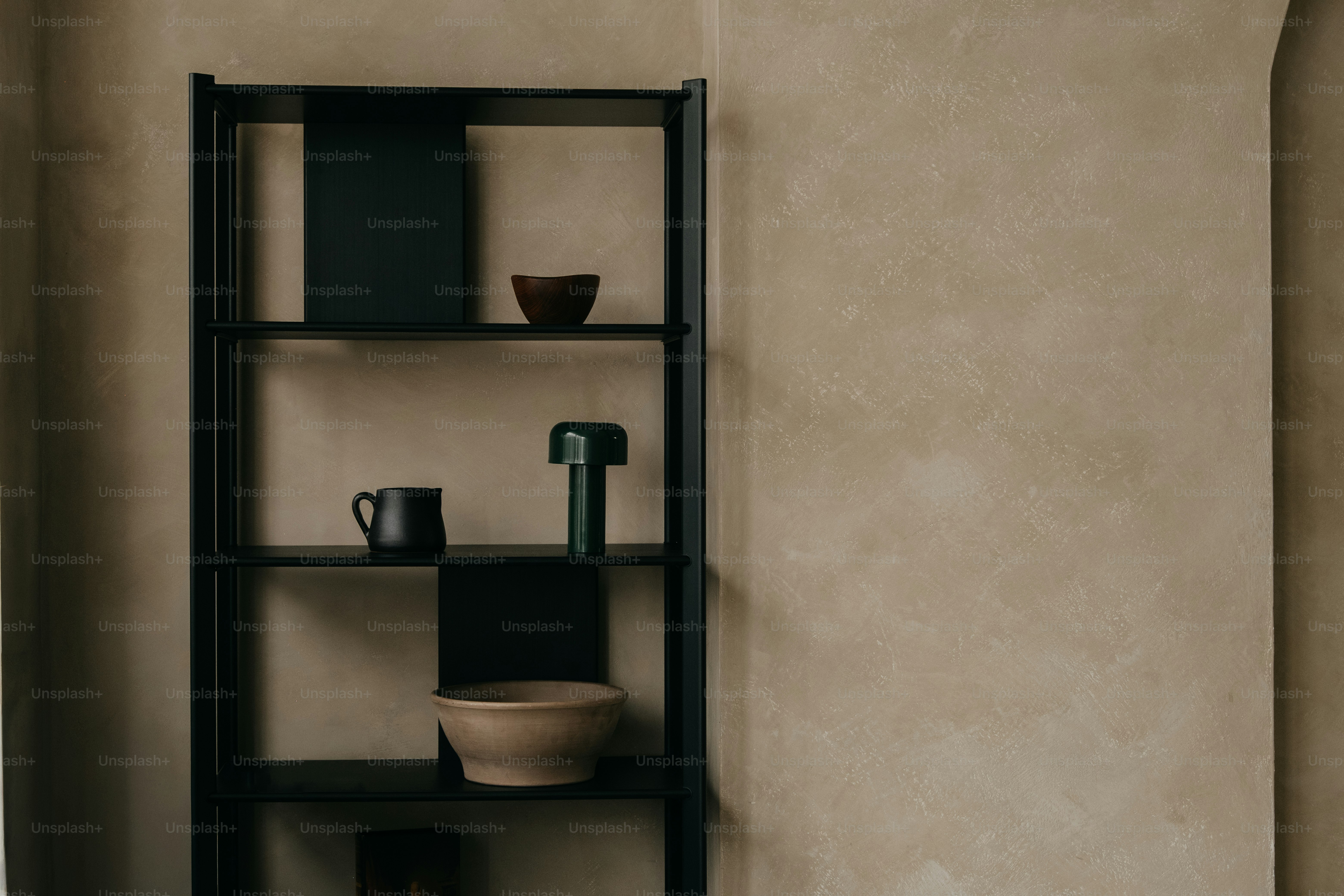 A minimalist black shelf with decorative items.