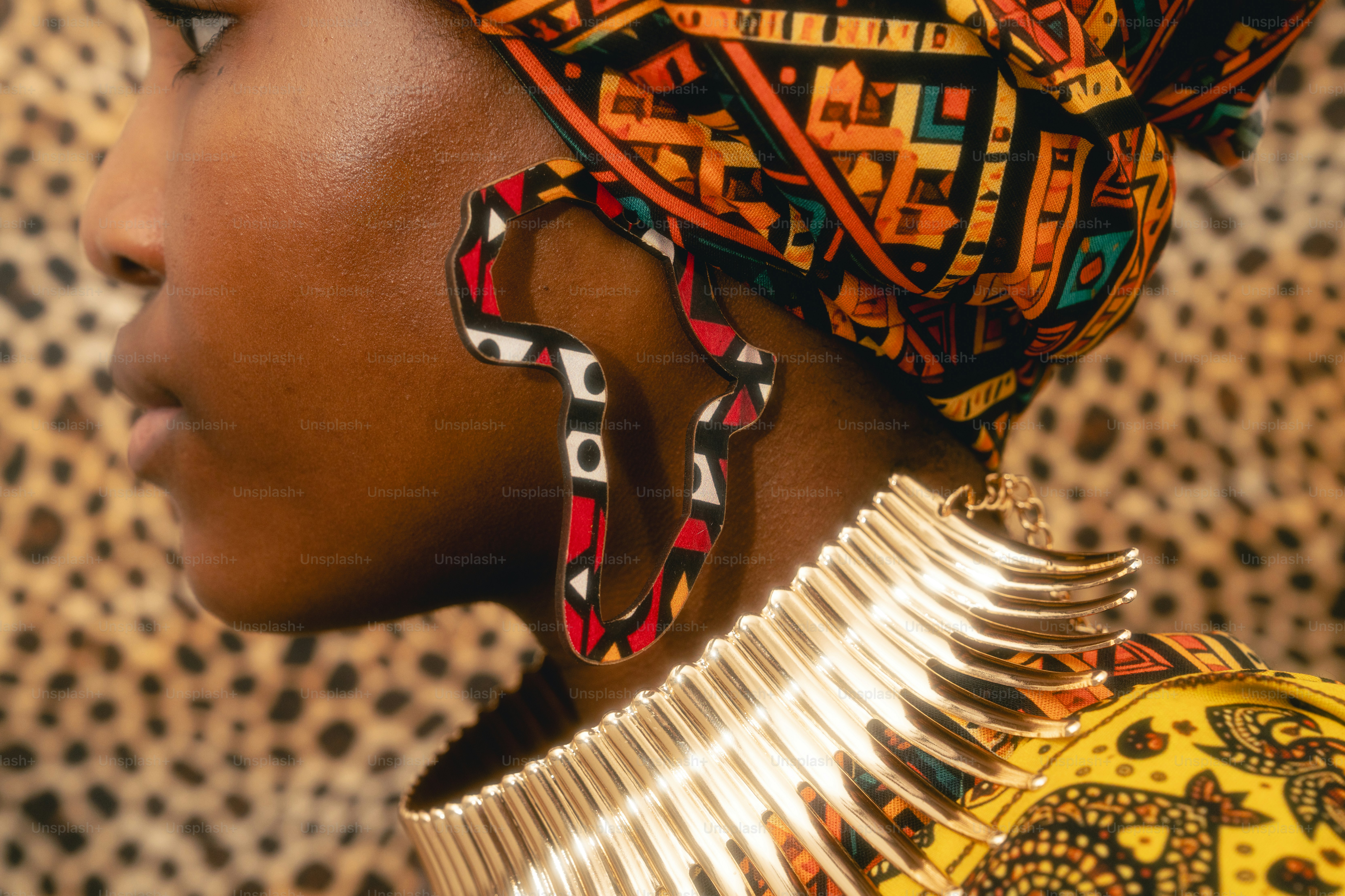 Woman wearing colorful african print headwrap and large earrings.