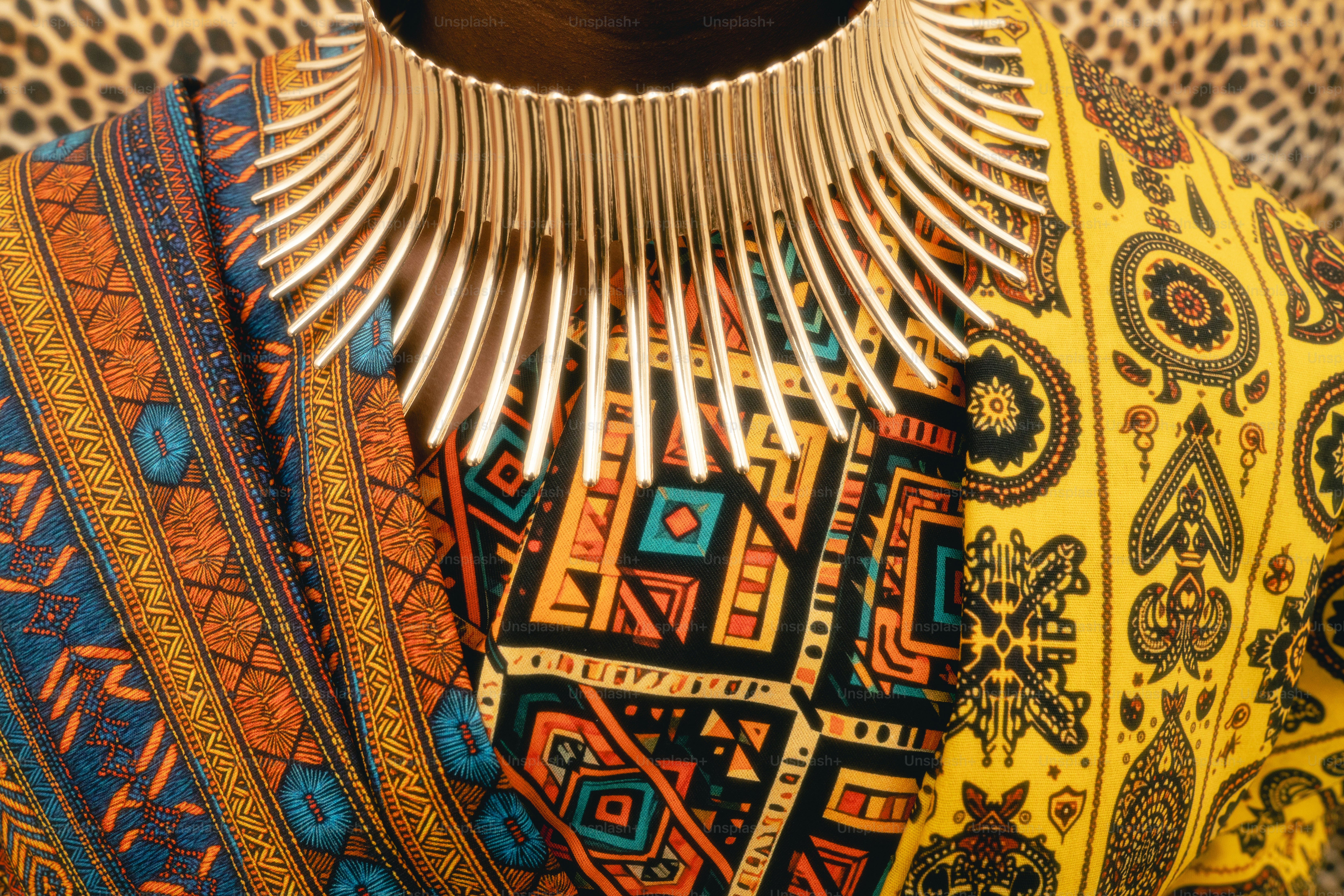 A tribal necklace worn over colorful patterned fabric