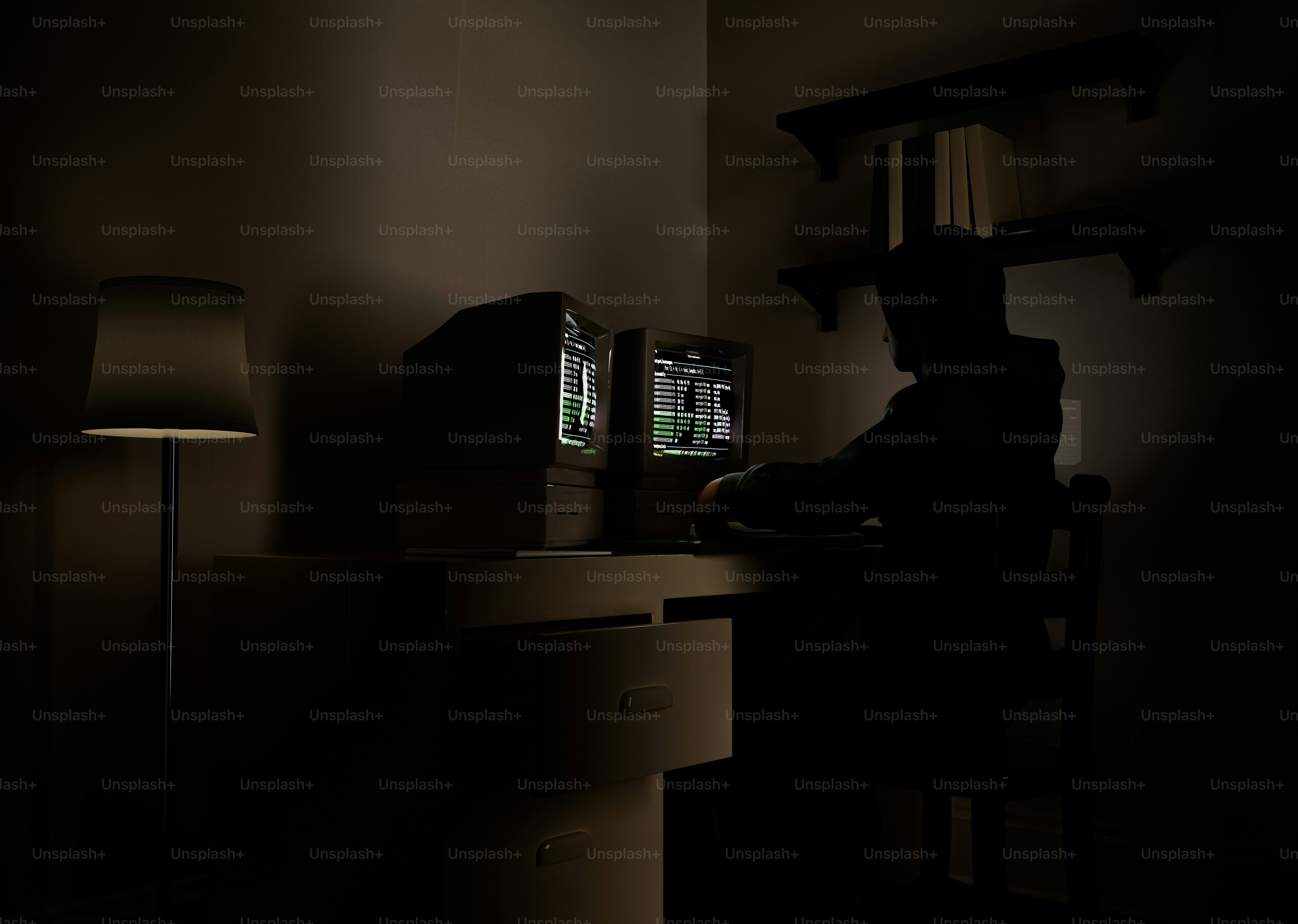 Person working on computer in dimly lit room.