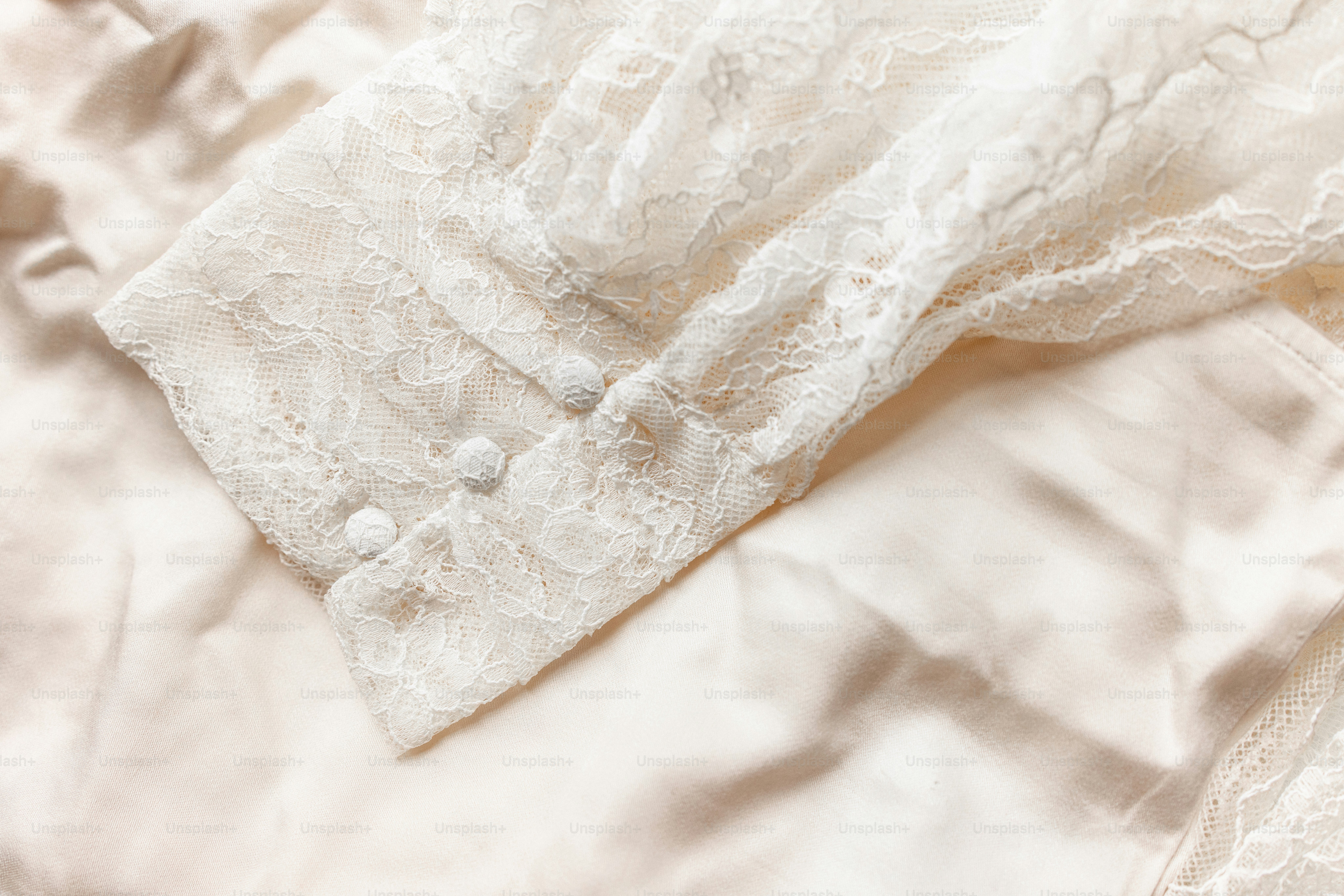 Close-up of a white lace sleeve with buttons
