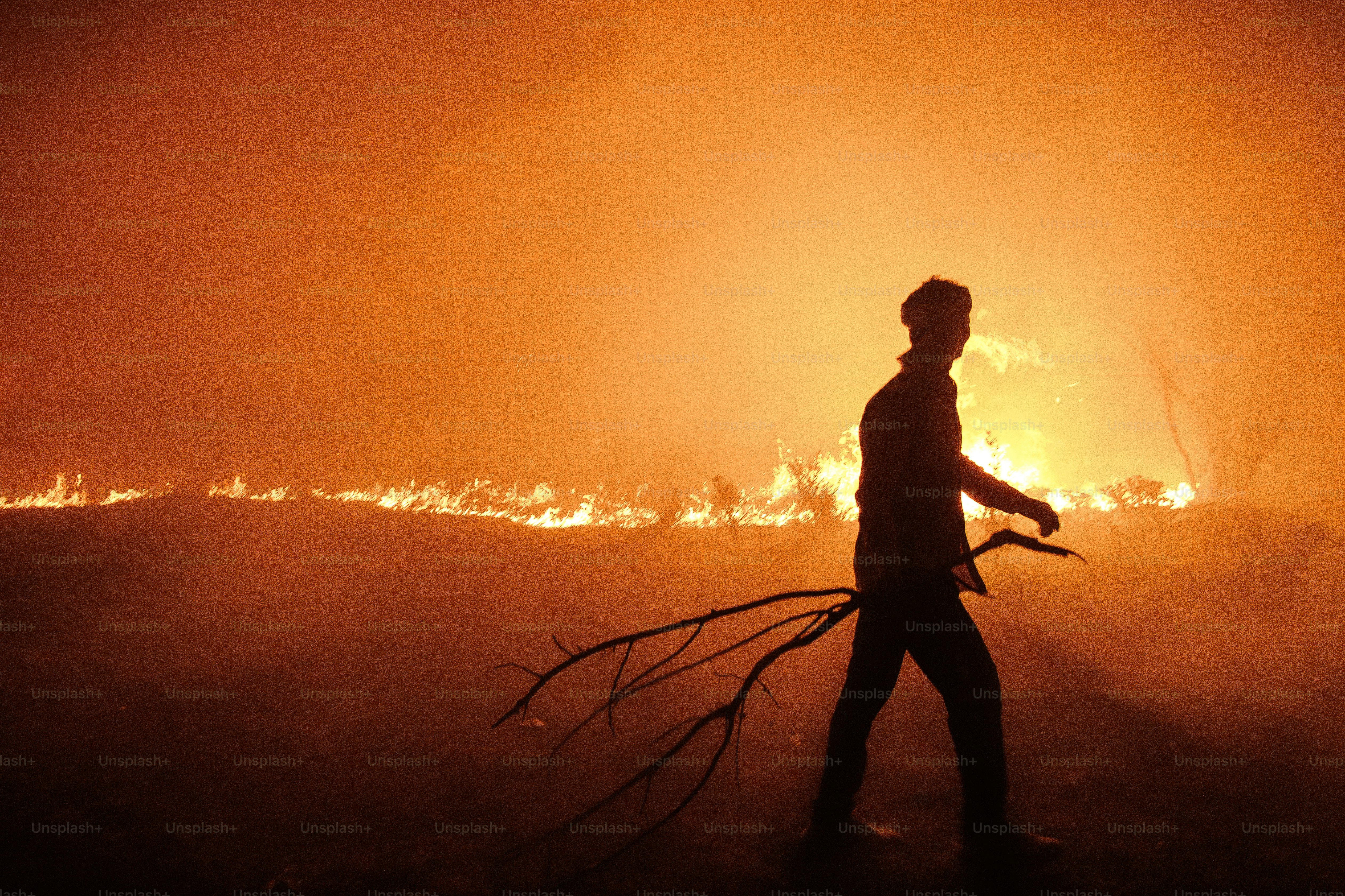 Man walks through smoke and fire at night