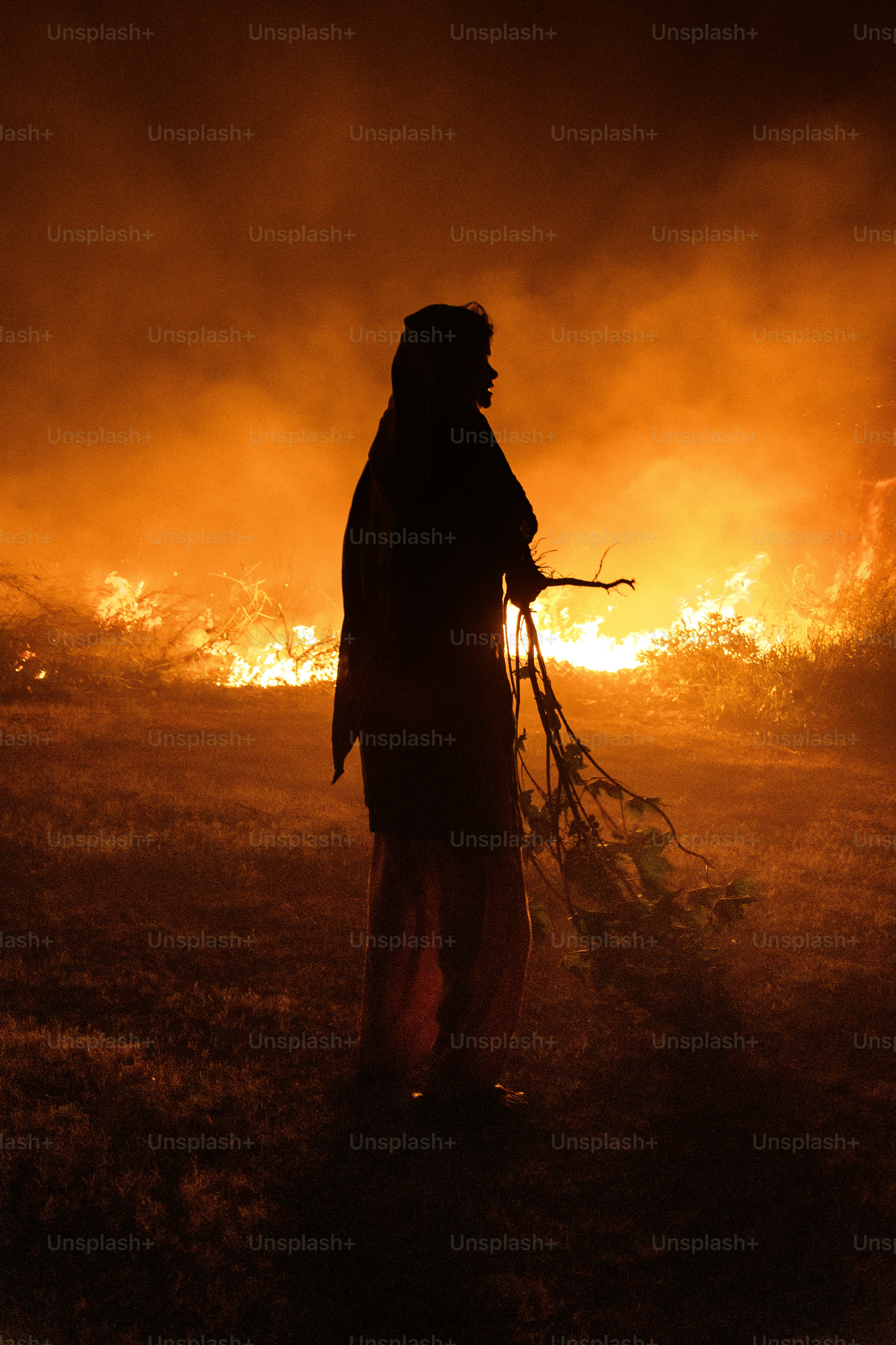 Silhouette of a person against a fiery background.