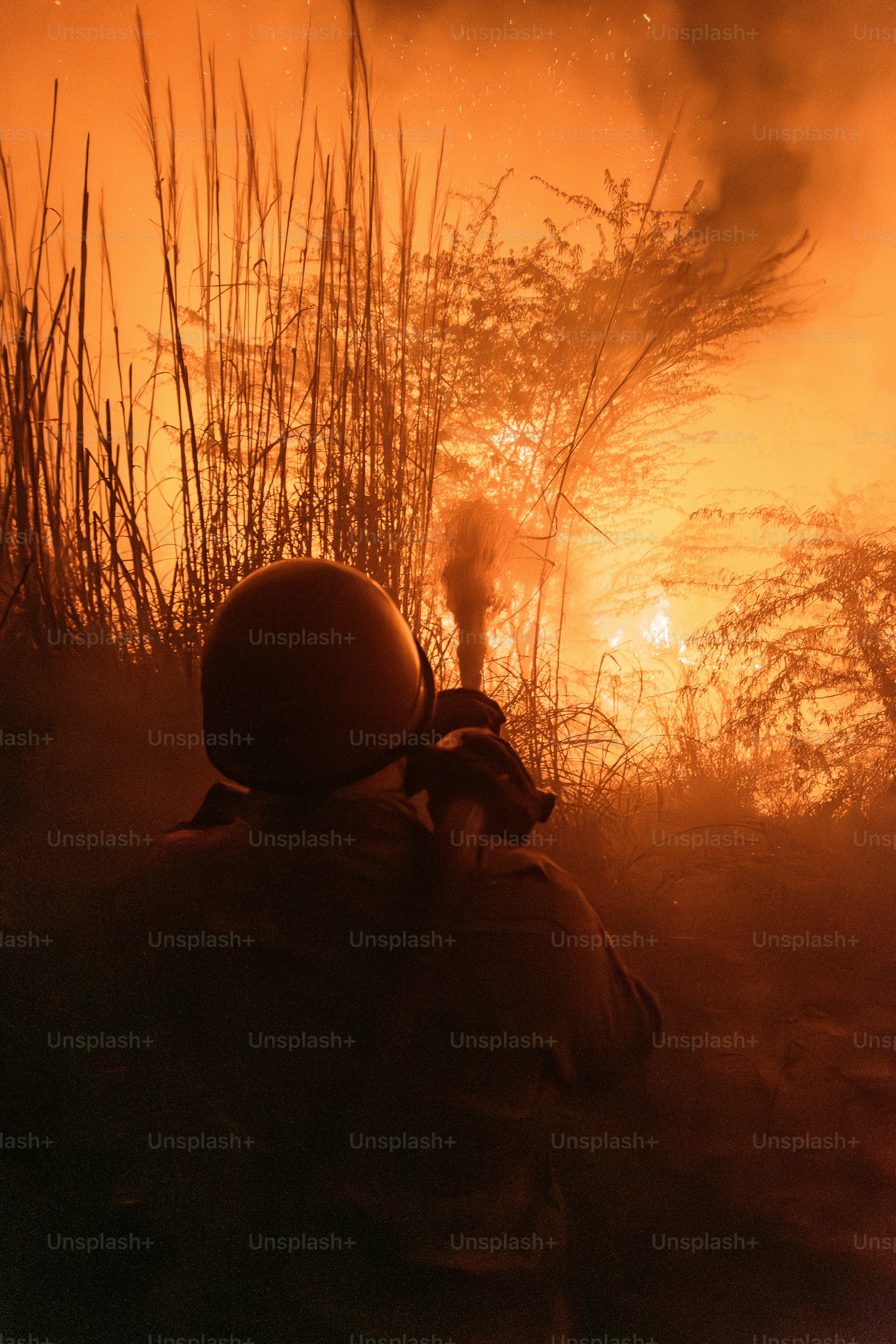 Soldier firing flare gun in smoky, fiery landscape