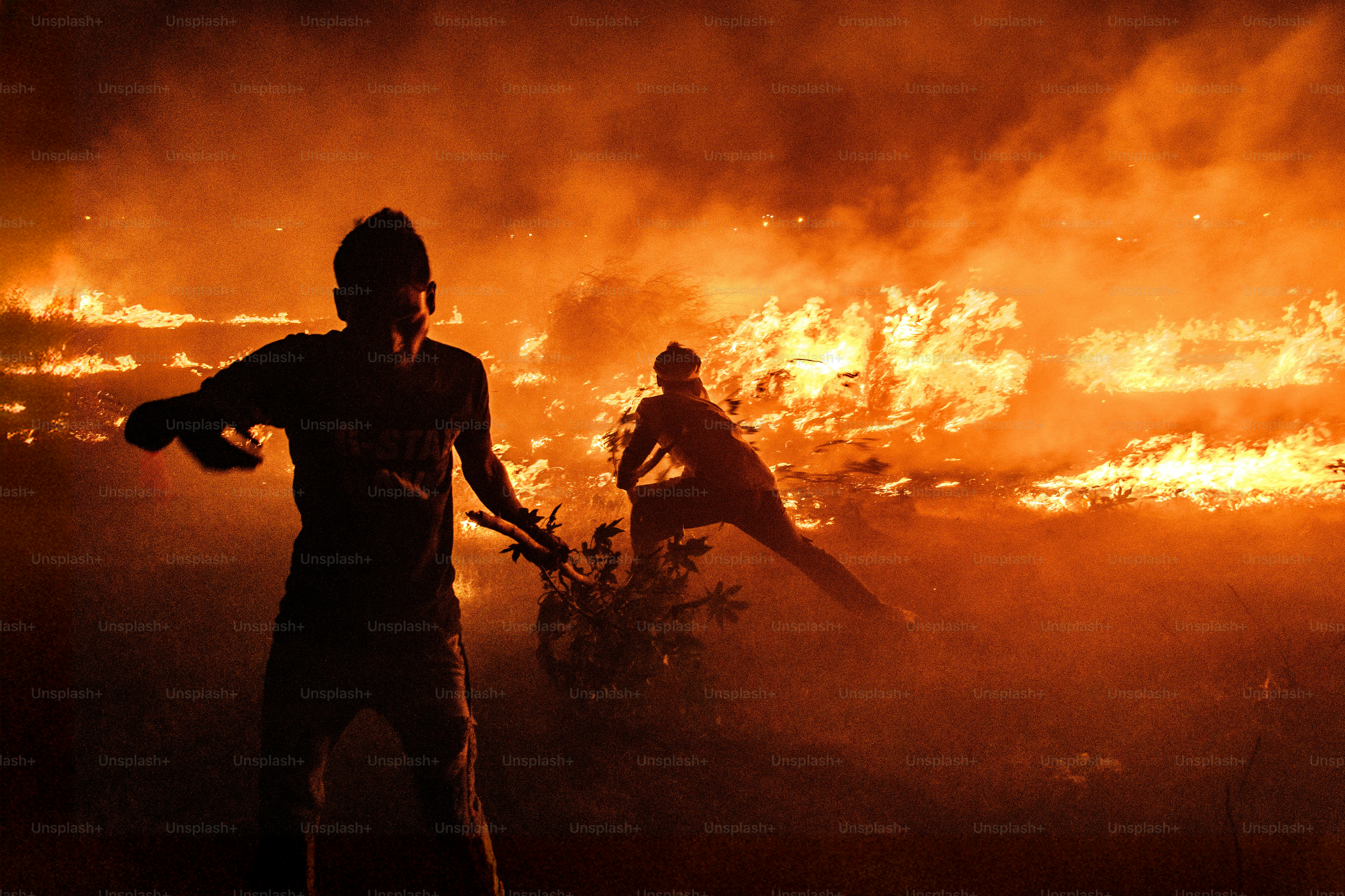 Silhouettes of people against a raging inferno