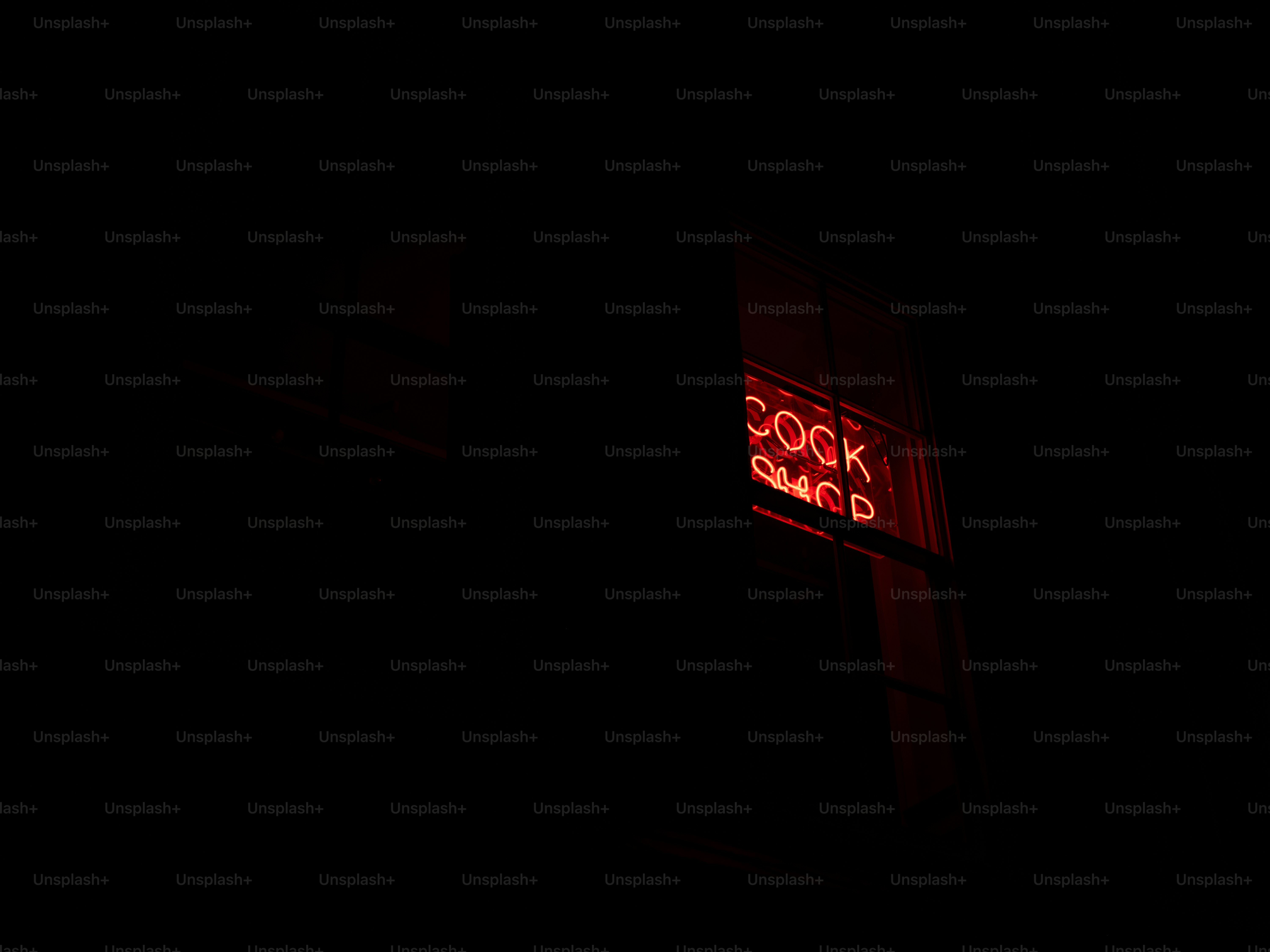 Enseigne au néon rouge pour un cock shop la nuit