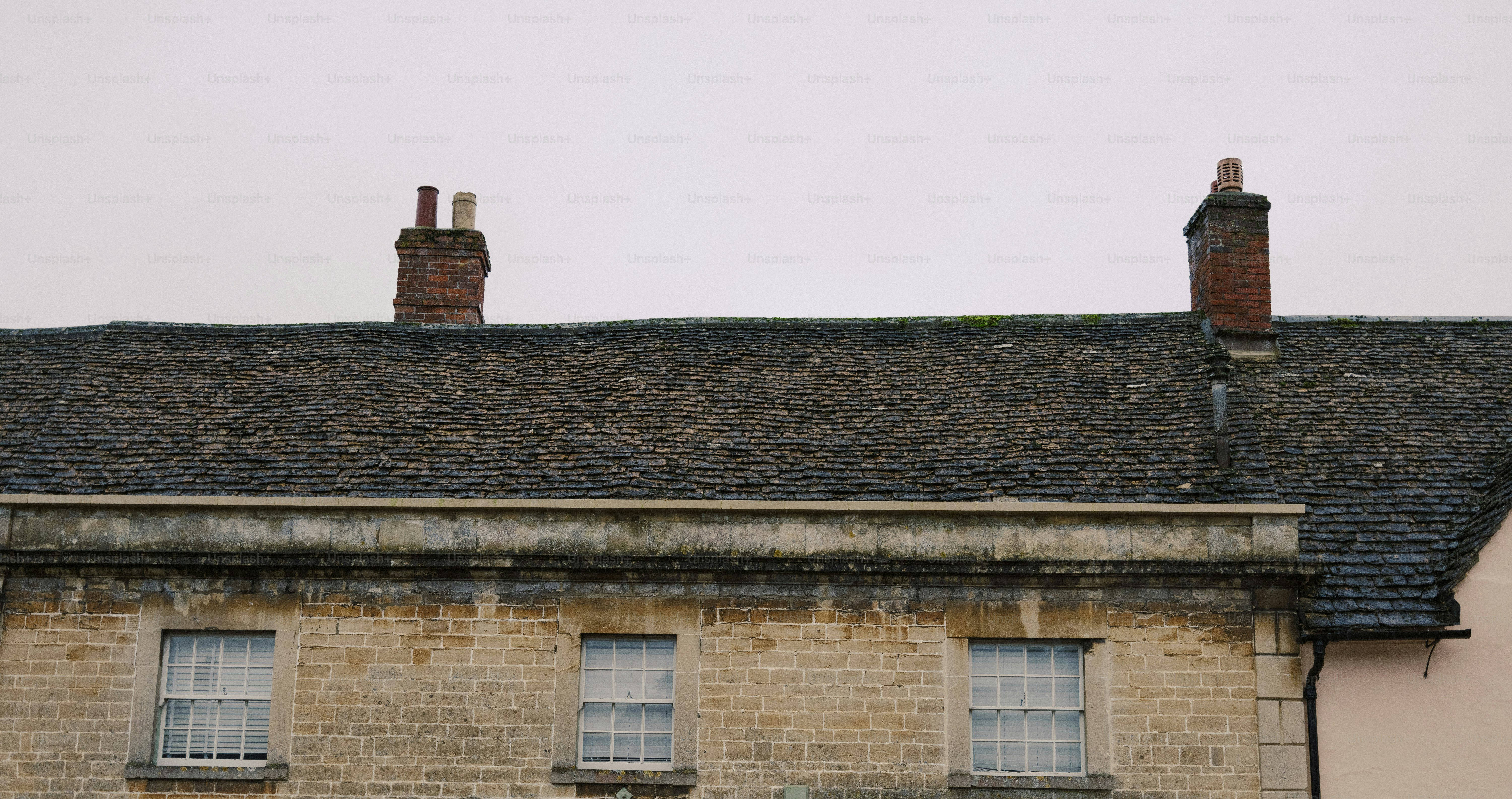 Rooftops and chimneys against a cloudy sky.