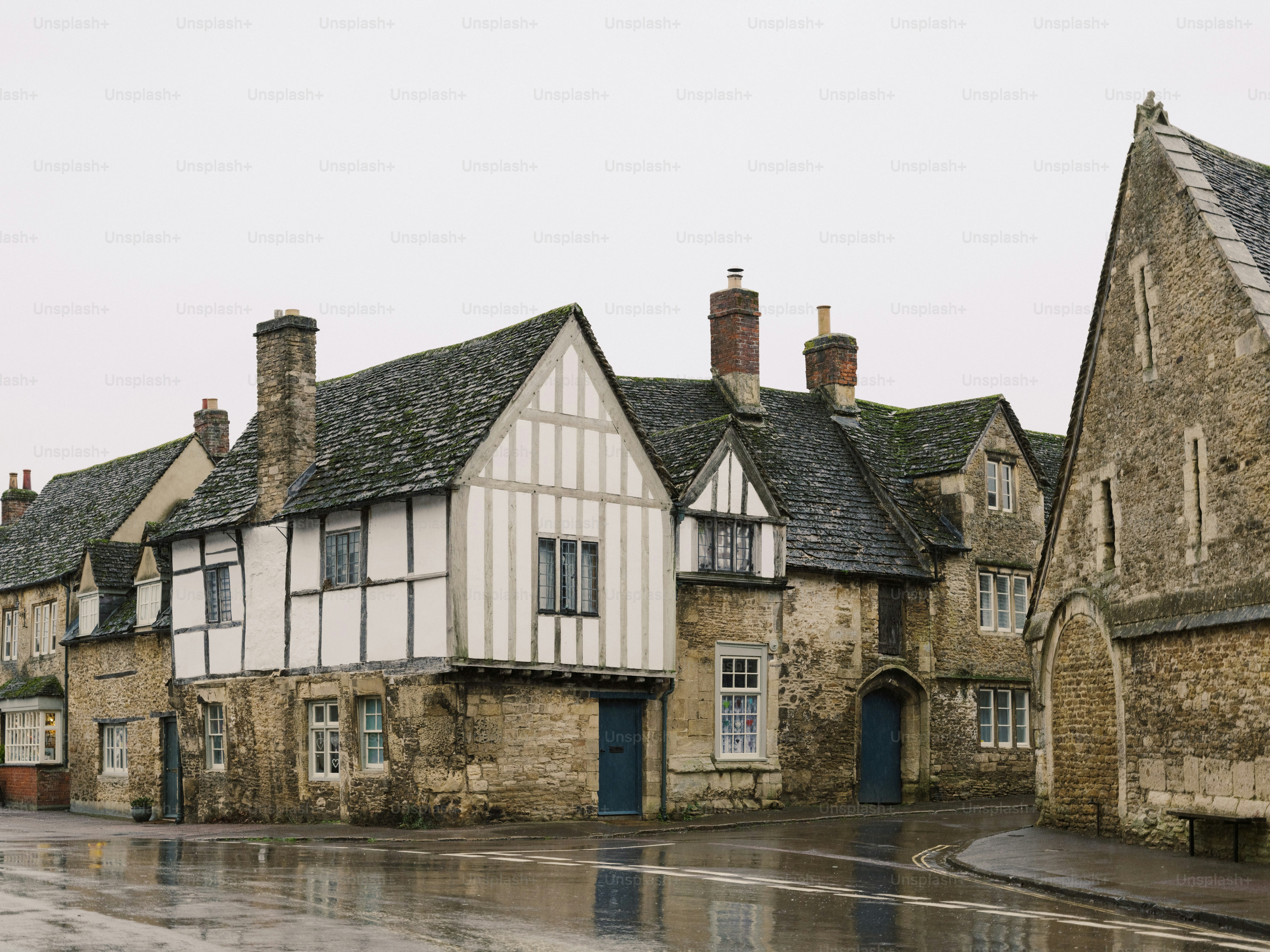 Historic timber-framed buildings on a wet street.