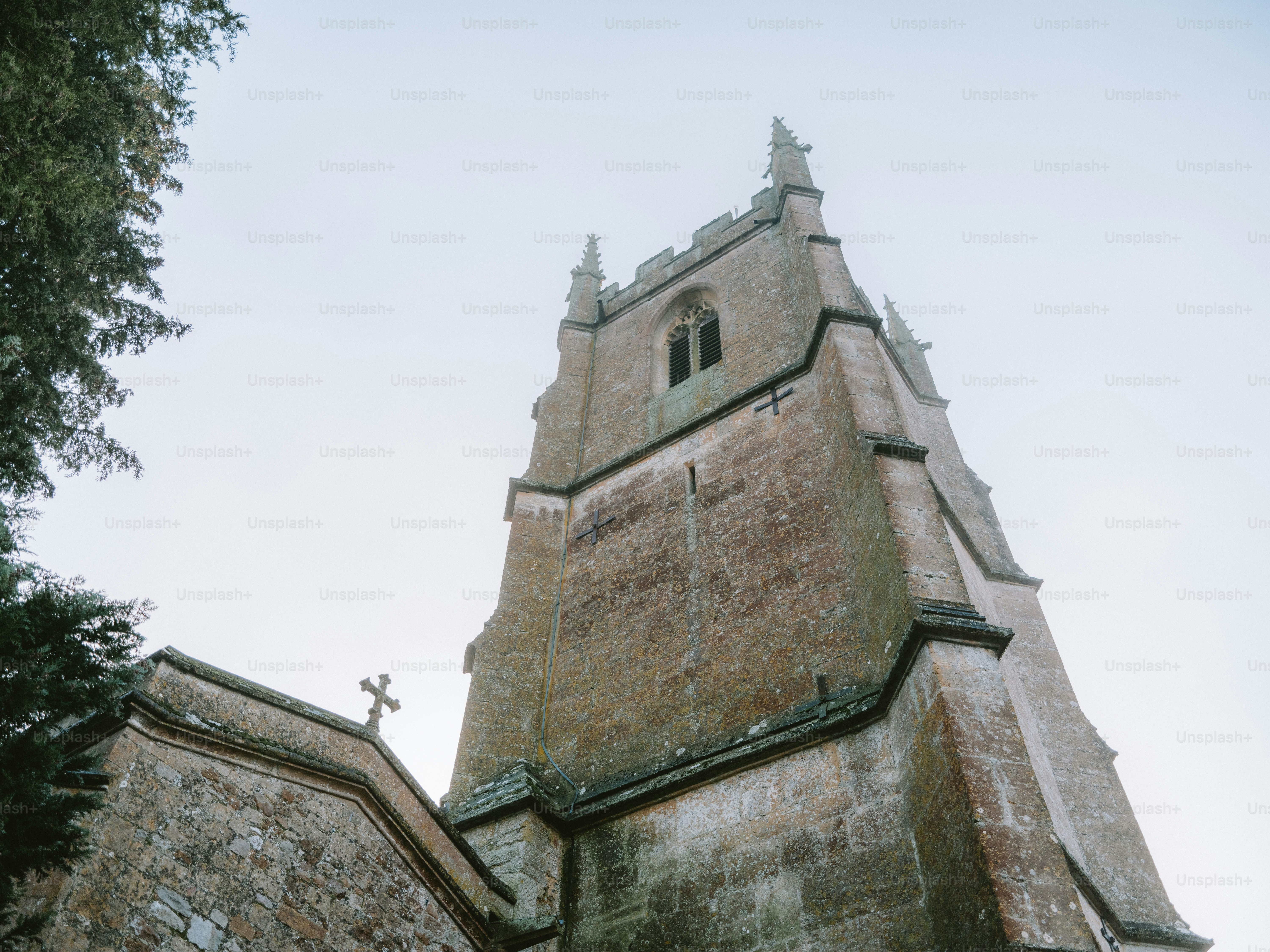 Stone church tower with a cross against sky