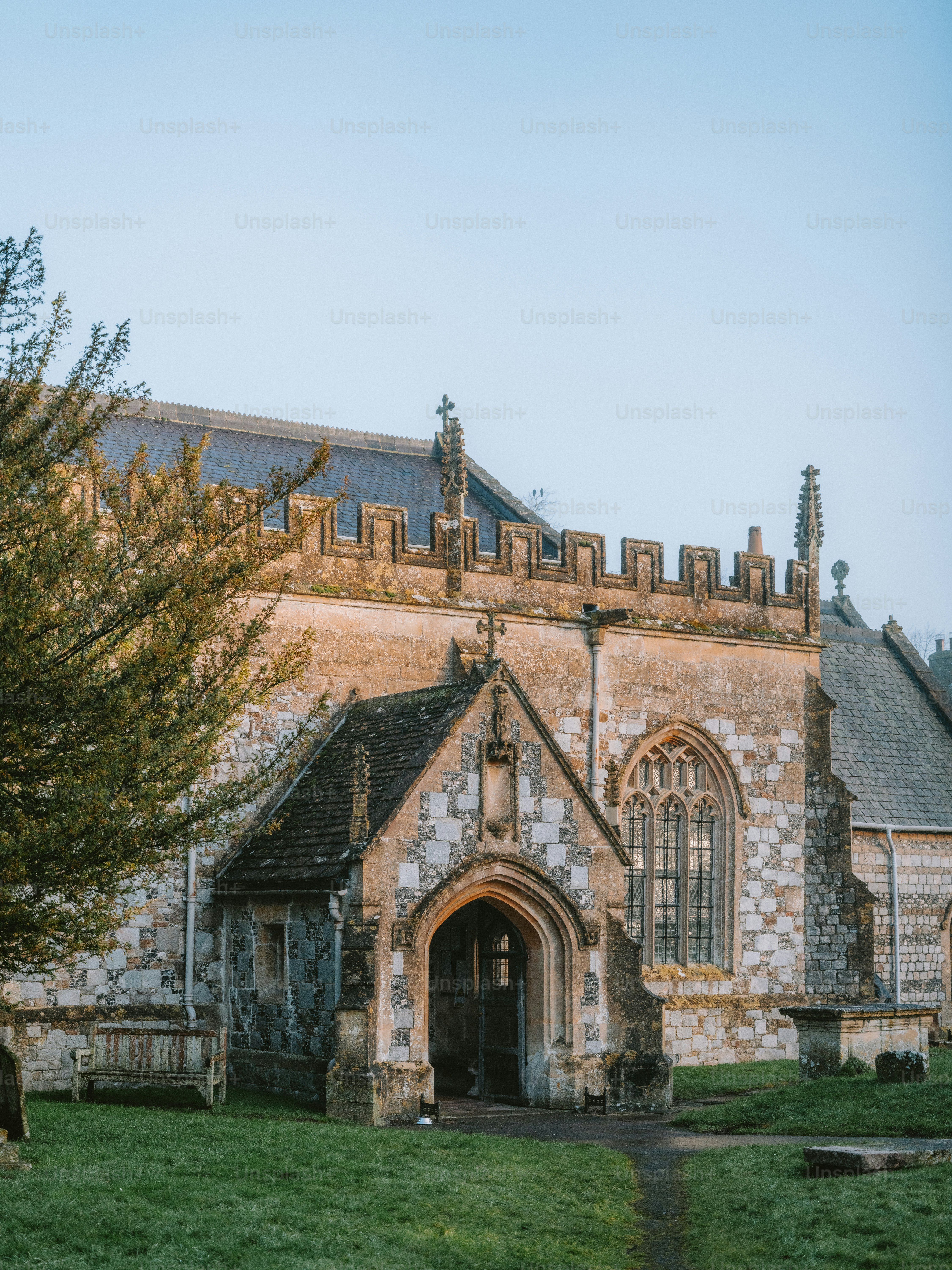 Entrada histórica de igreja de pedra com gramado verde