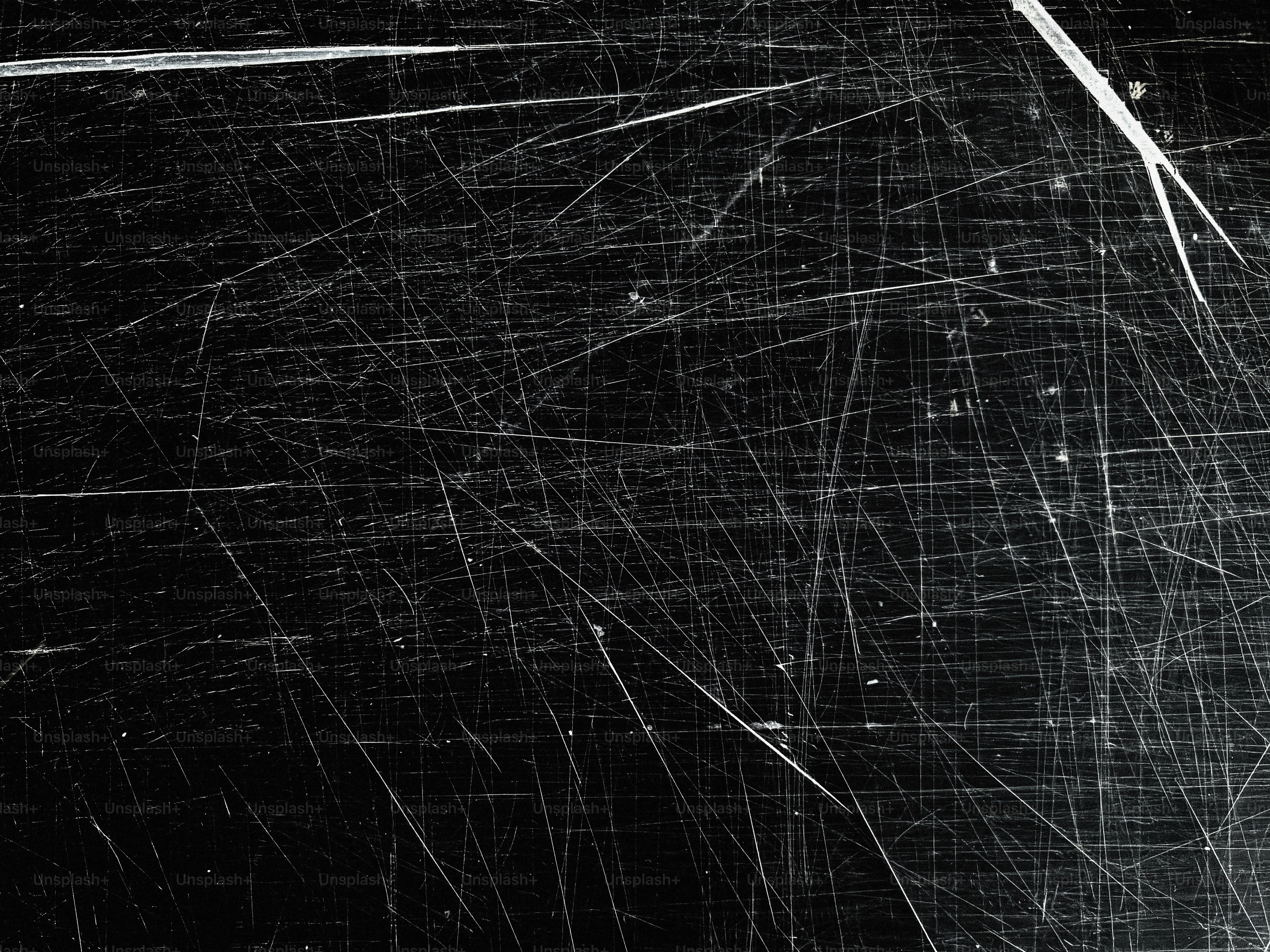 A black surface with many white scratches