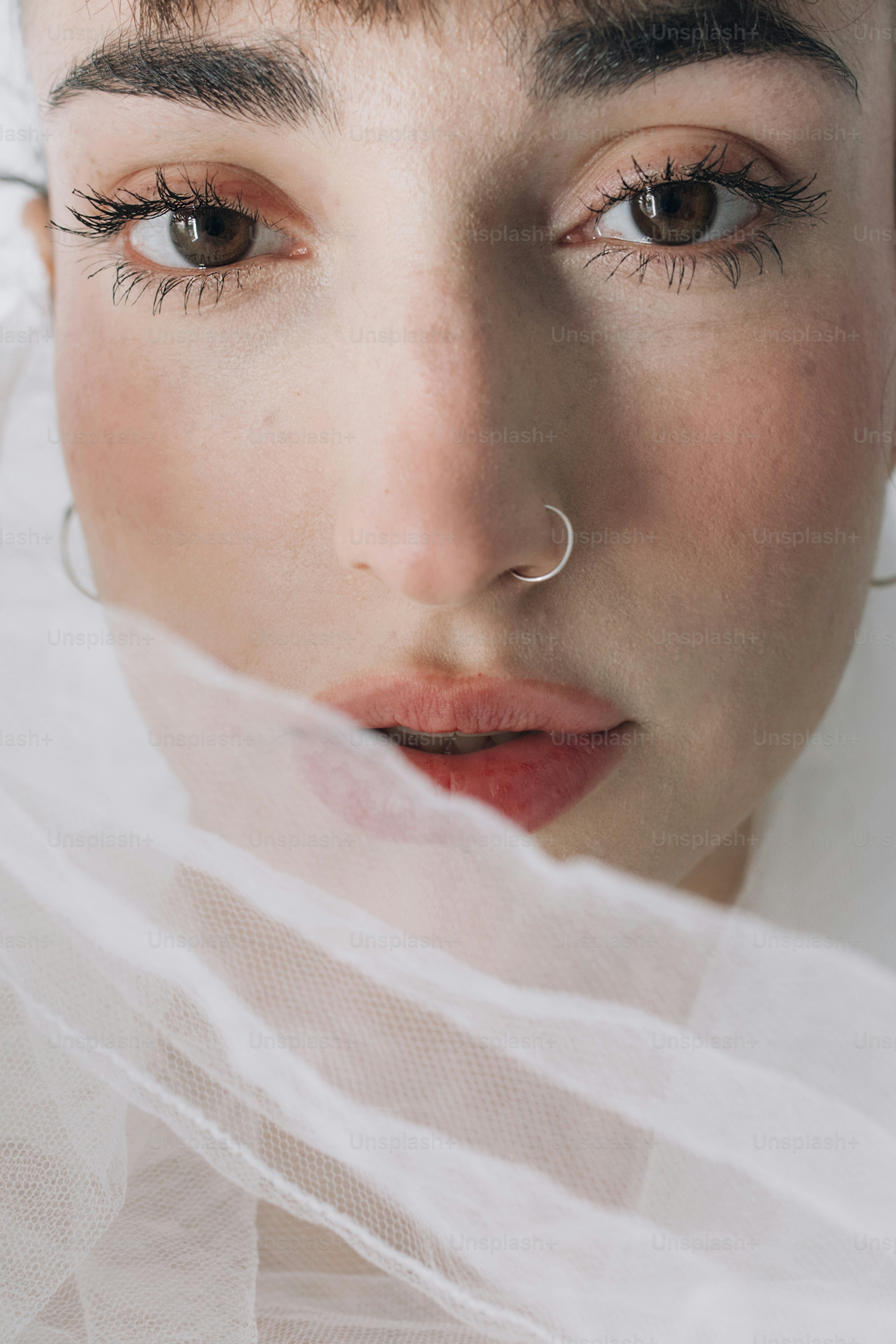 A close-up of a woman's face with a sheer veil.