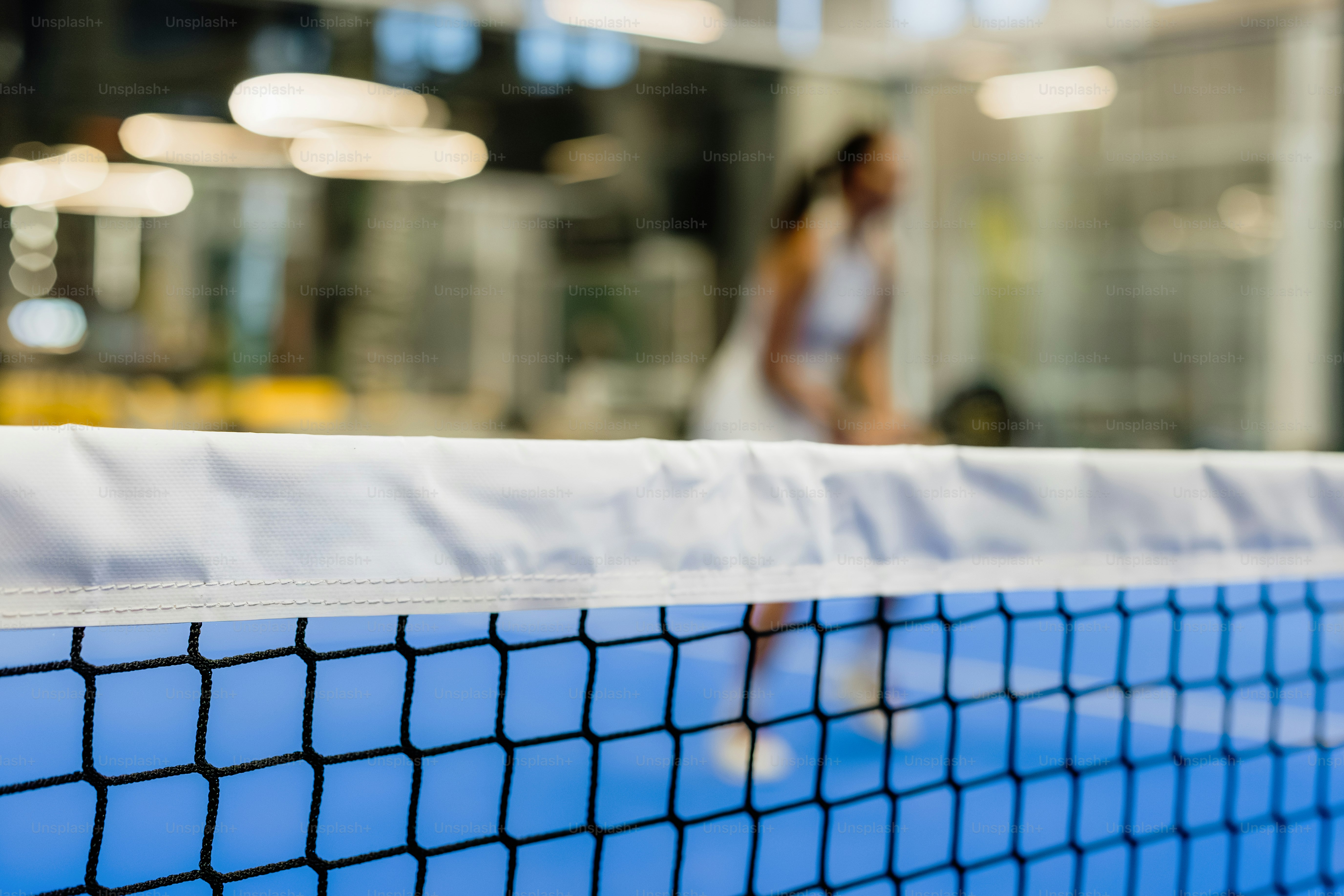 Woman playing tennis on a blue court