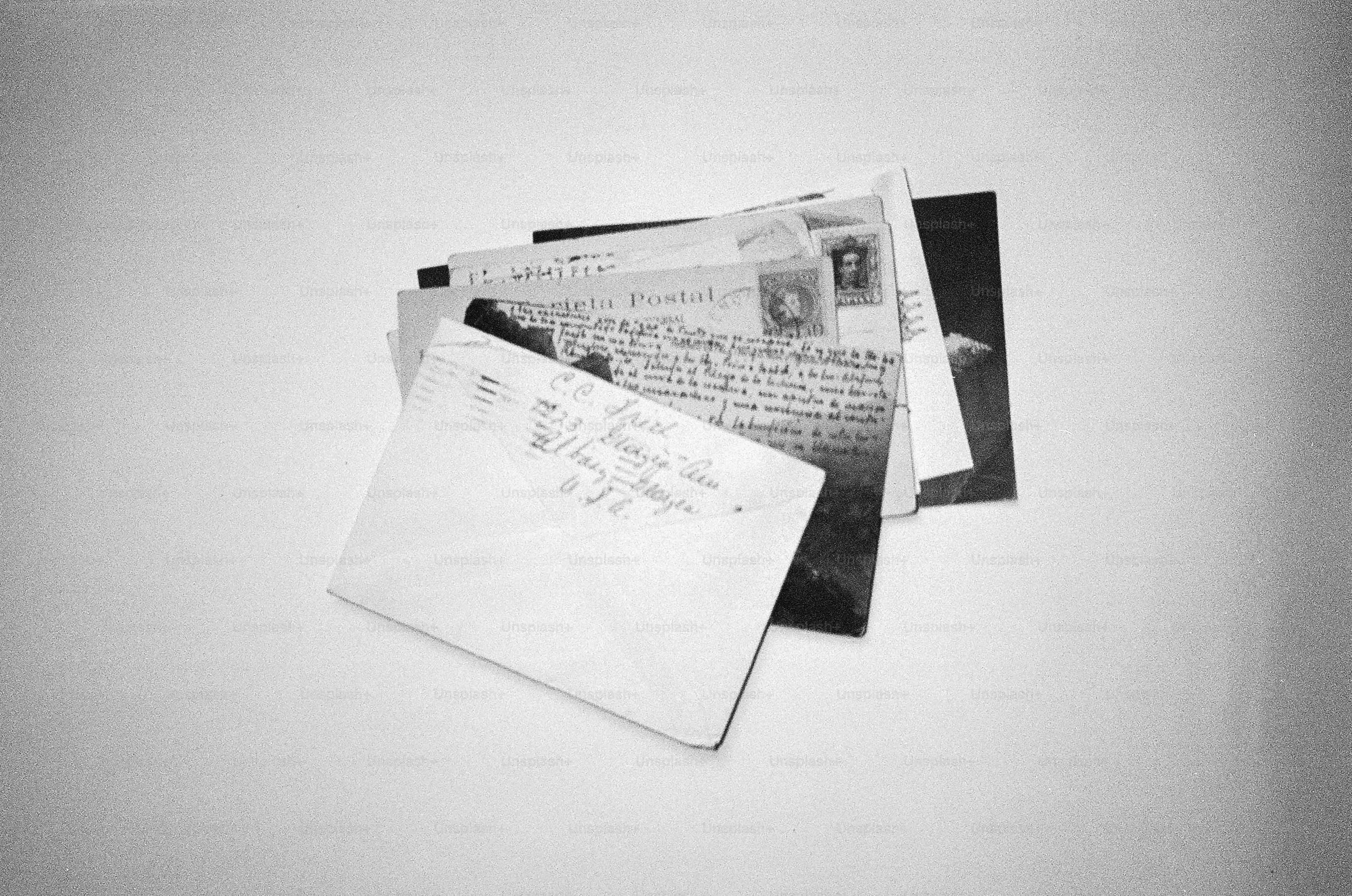 Stack of letters and envelopes on a white surface.