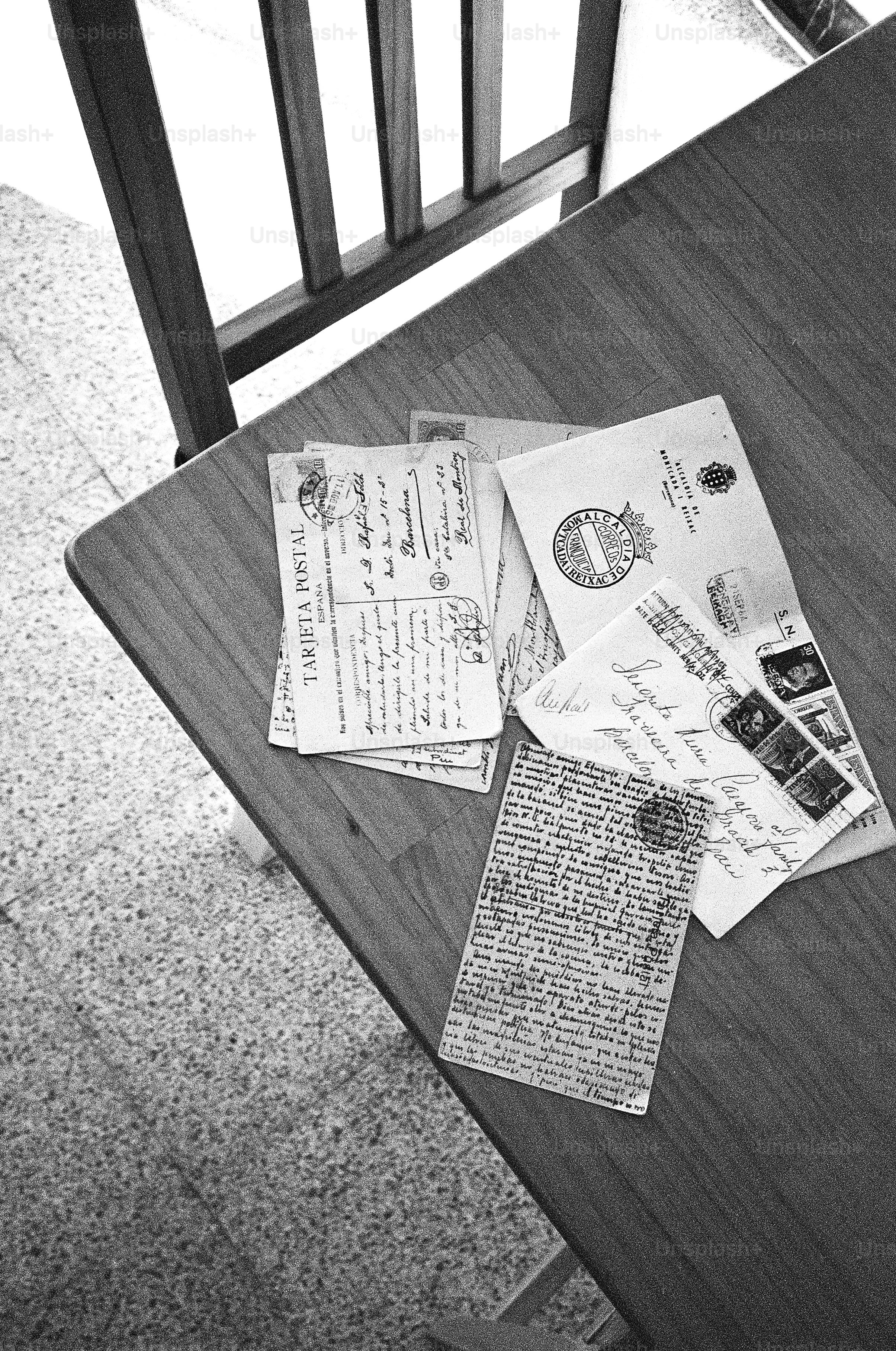 Antique letters and postcards scattered on a wooden table.