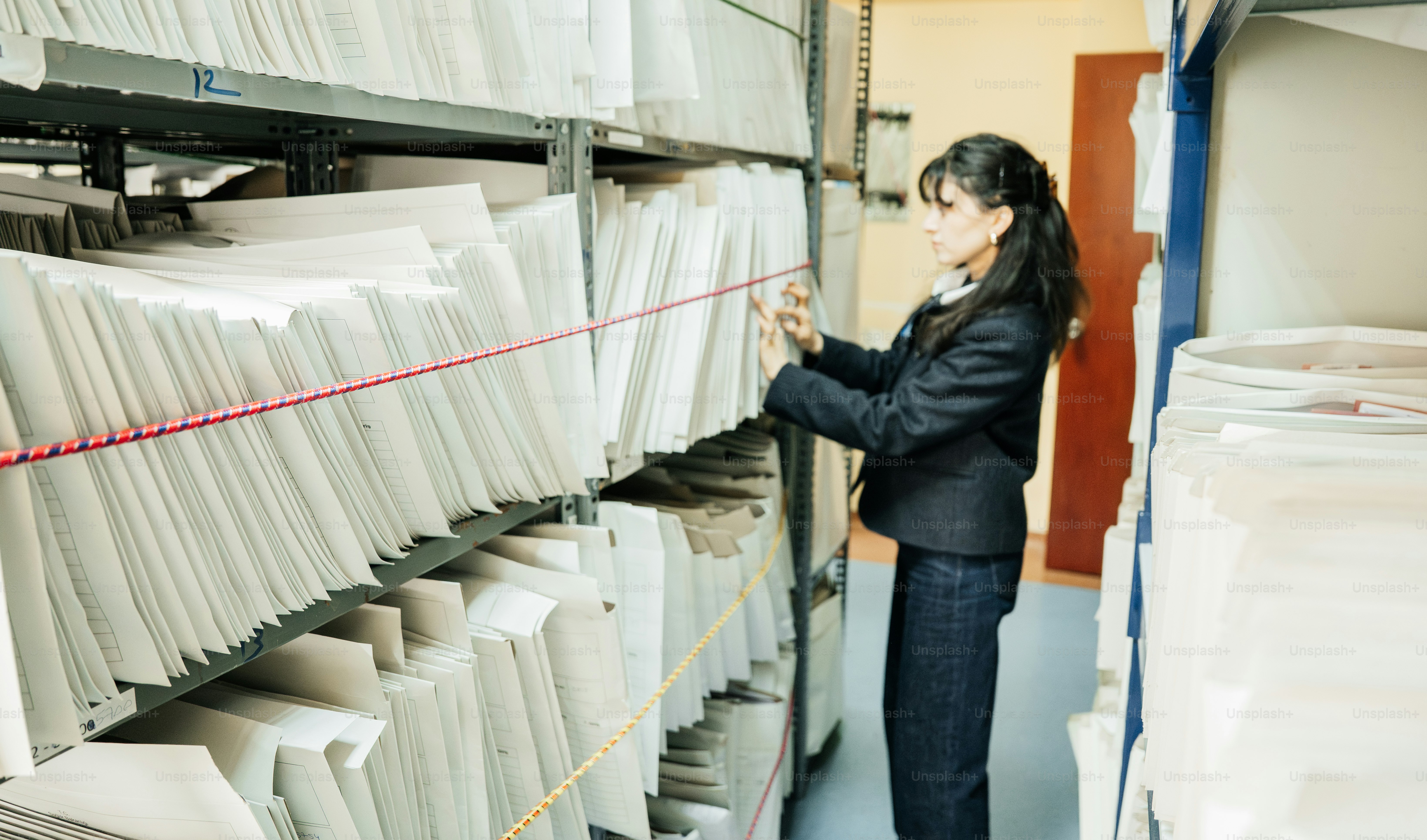 Woman organizing files in a large archive