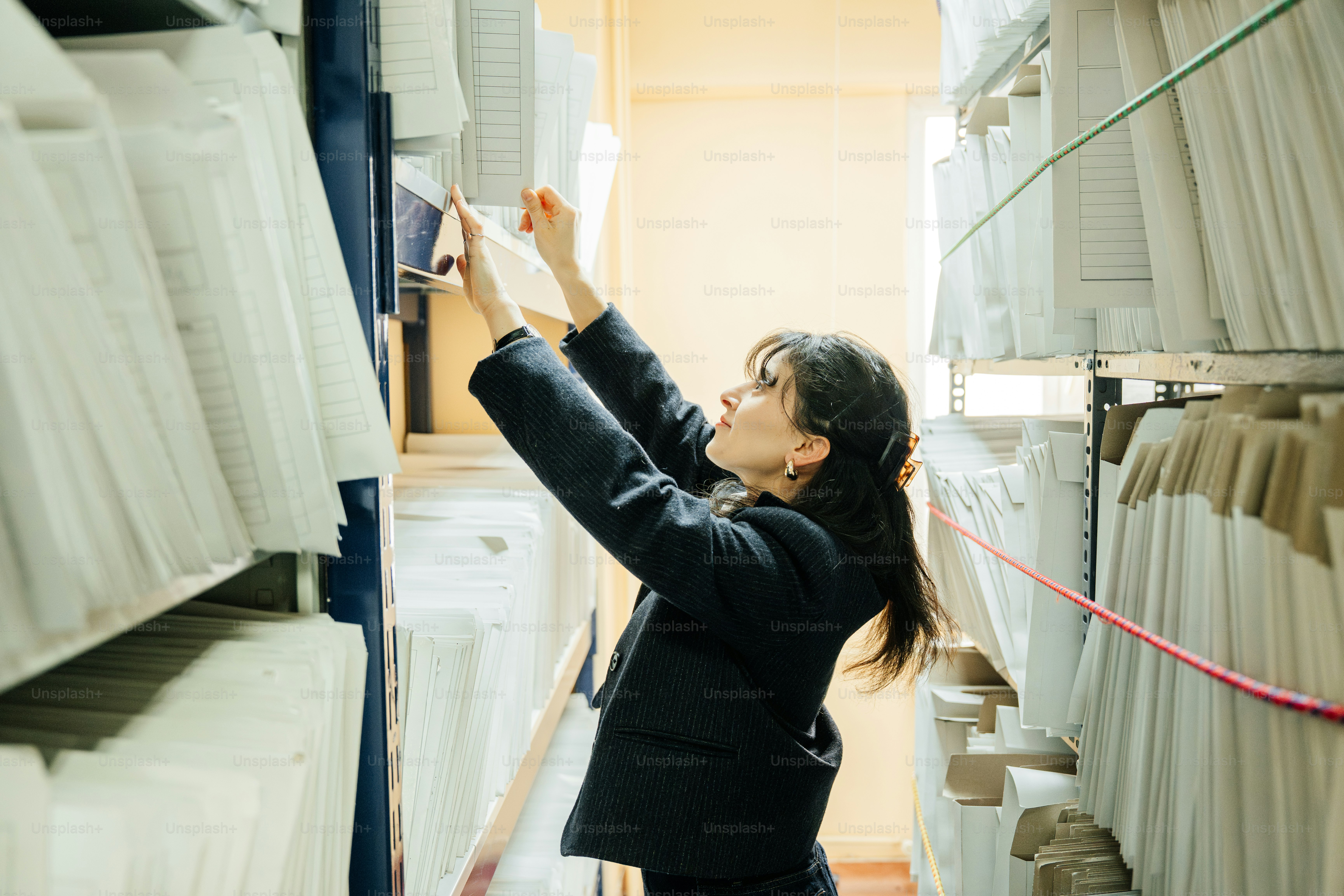 Woman reaching for file in archive