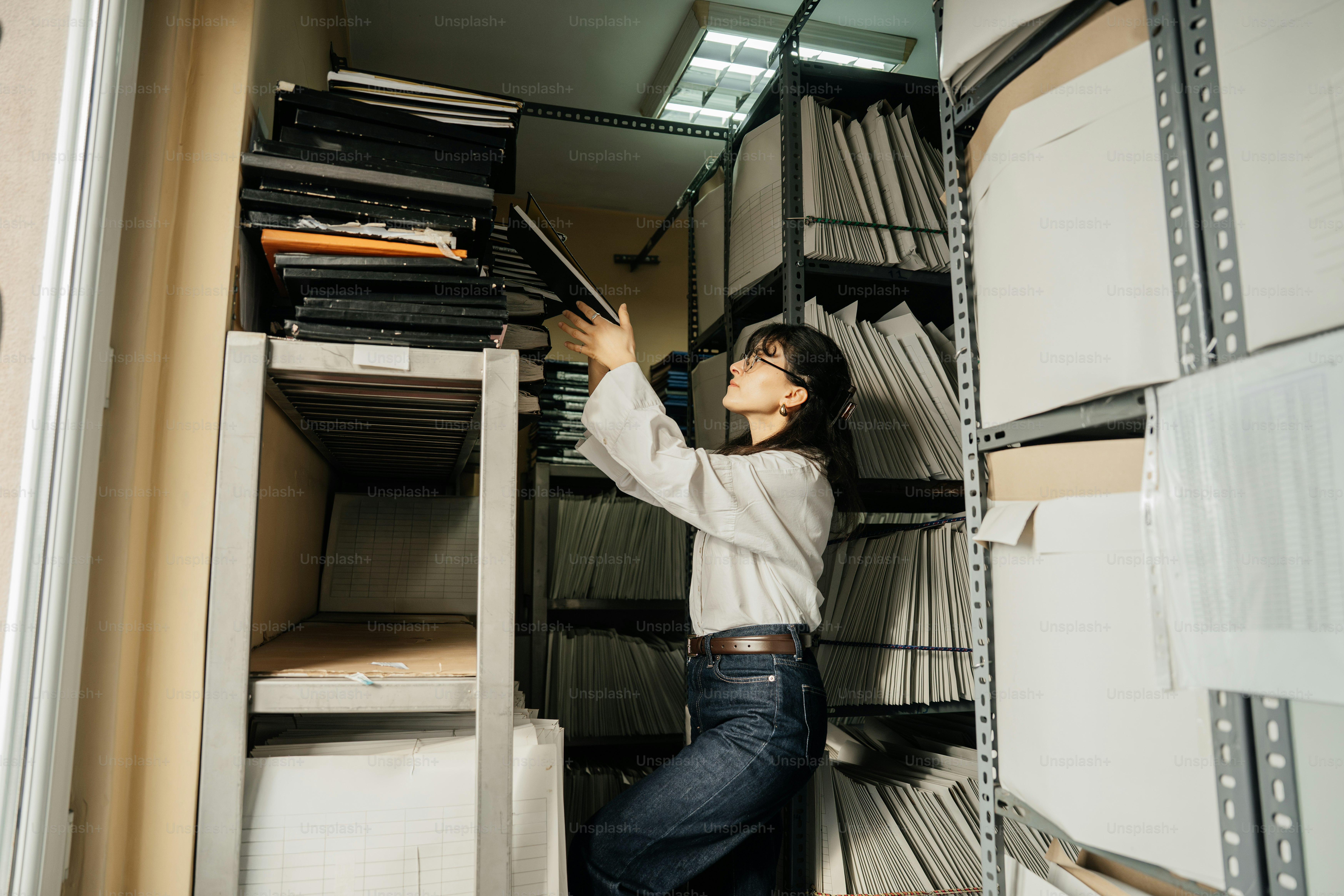 Woman reaching for files in a storage room