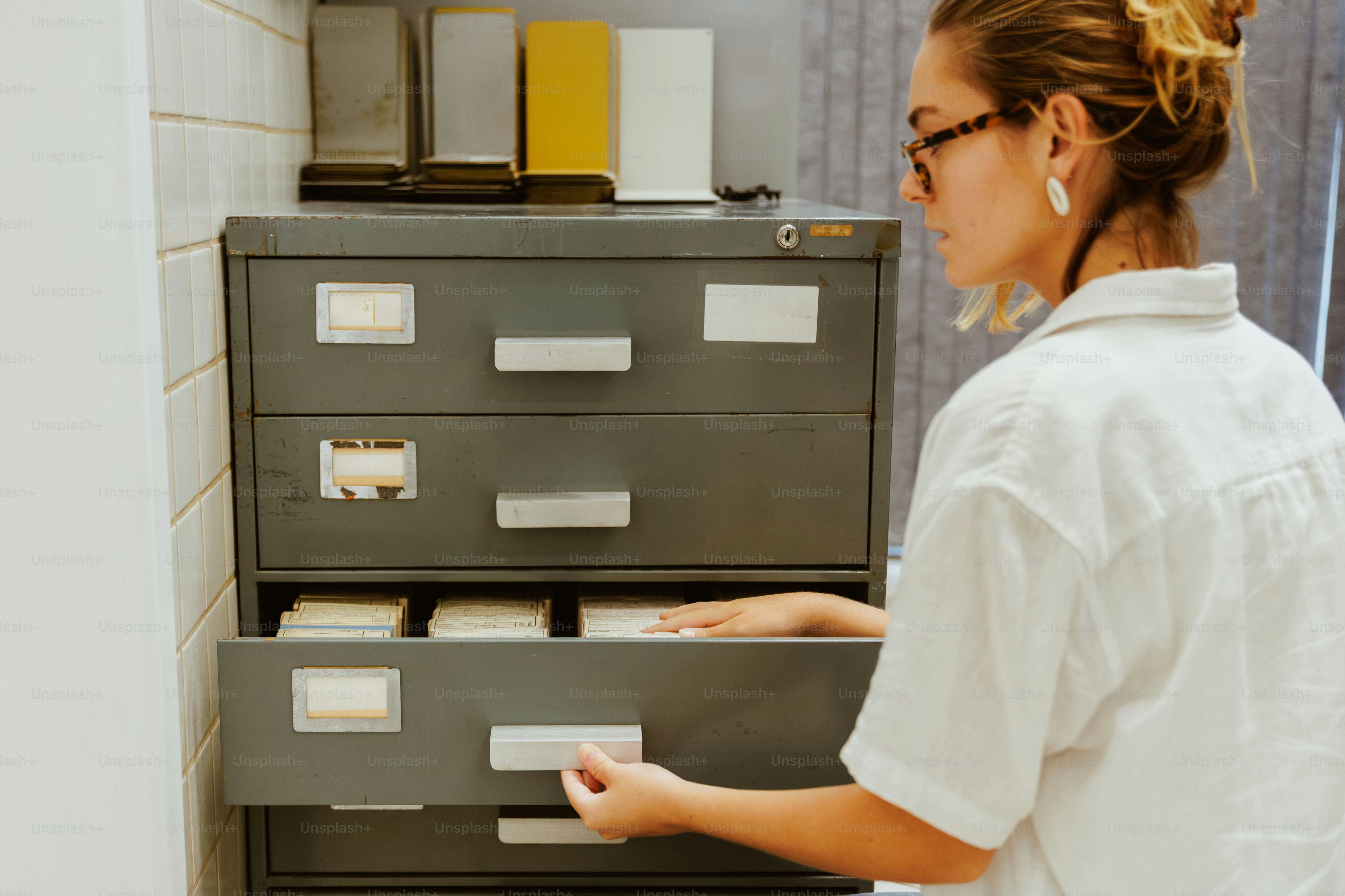 Woman looking through drawers of a filing cabinet