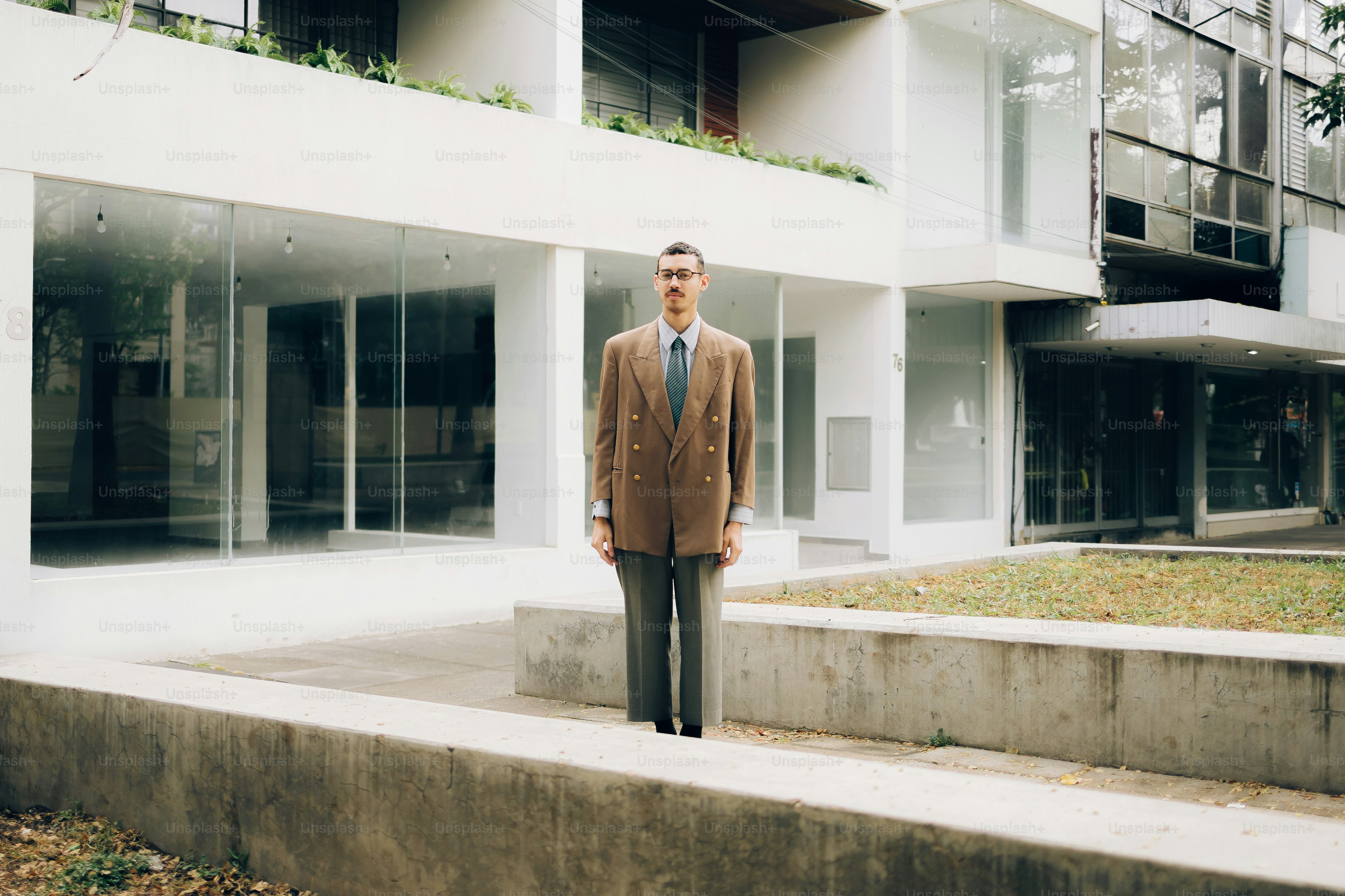 Mann im Anzug steht vor dem modernen Gebäude