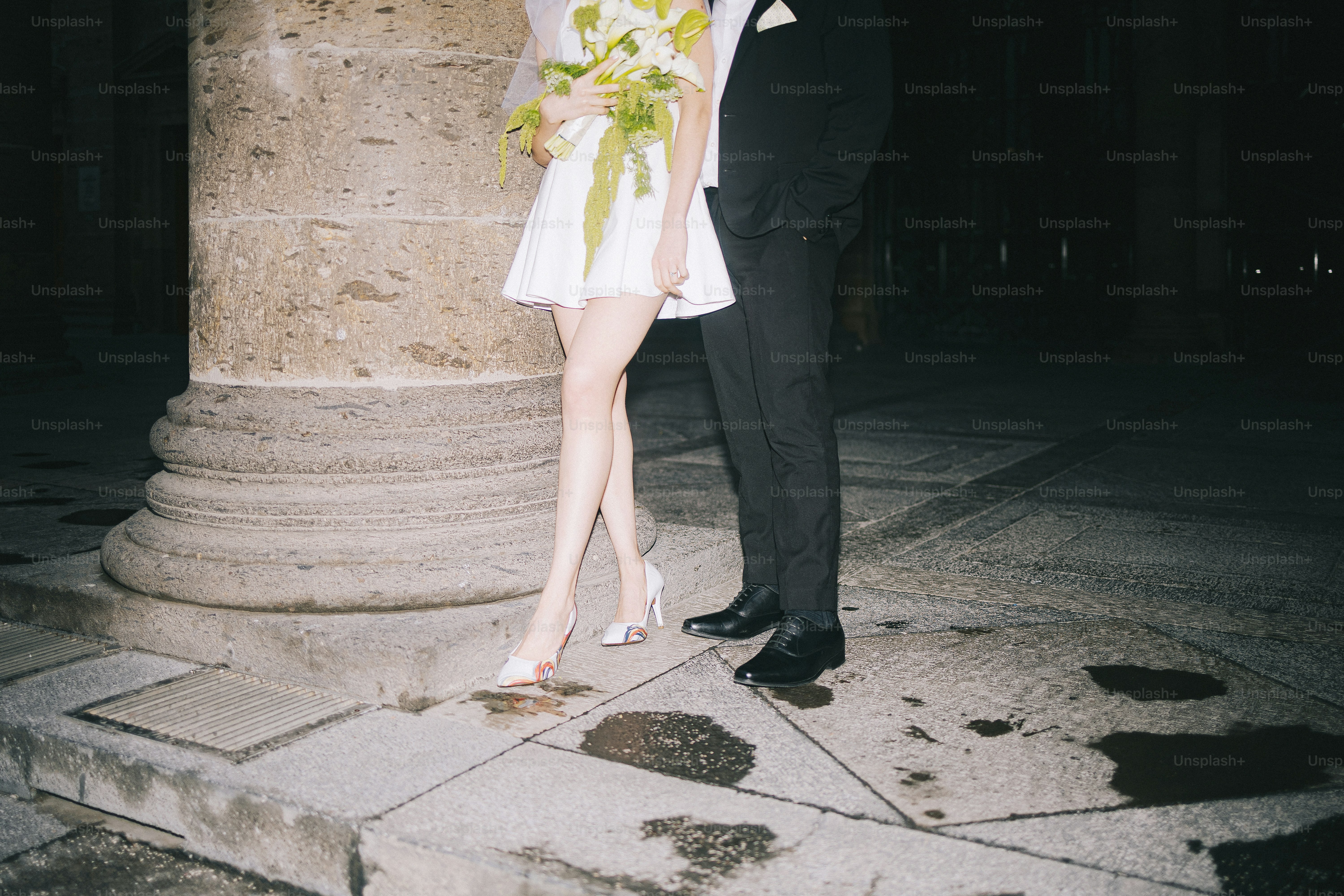 Bride and groom standing by a column