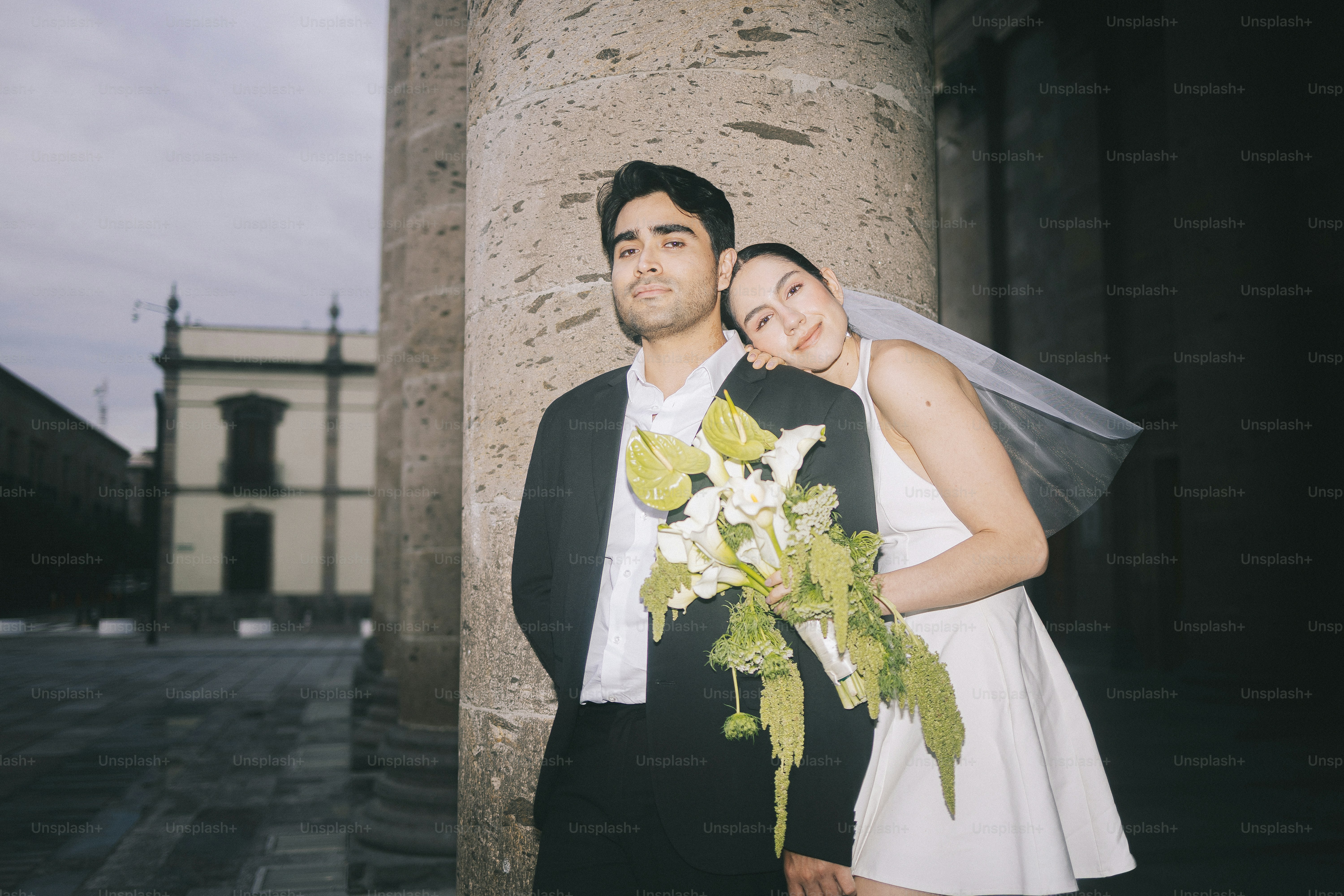 A bride rests her head on her groom's shoulder.