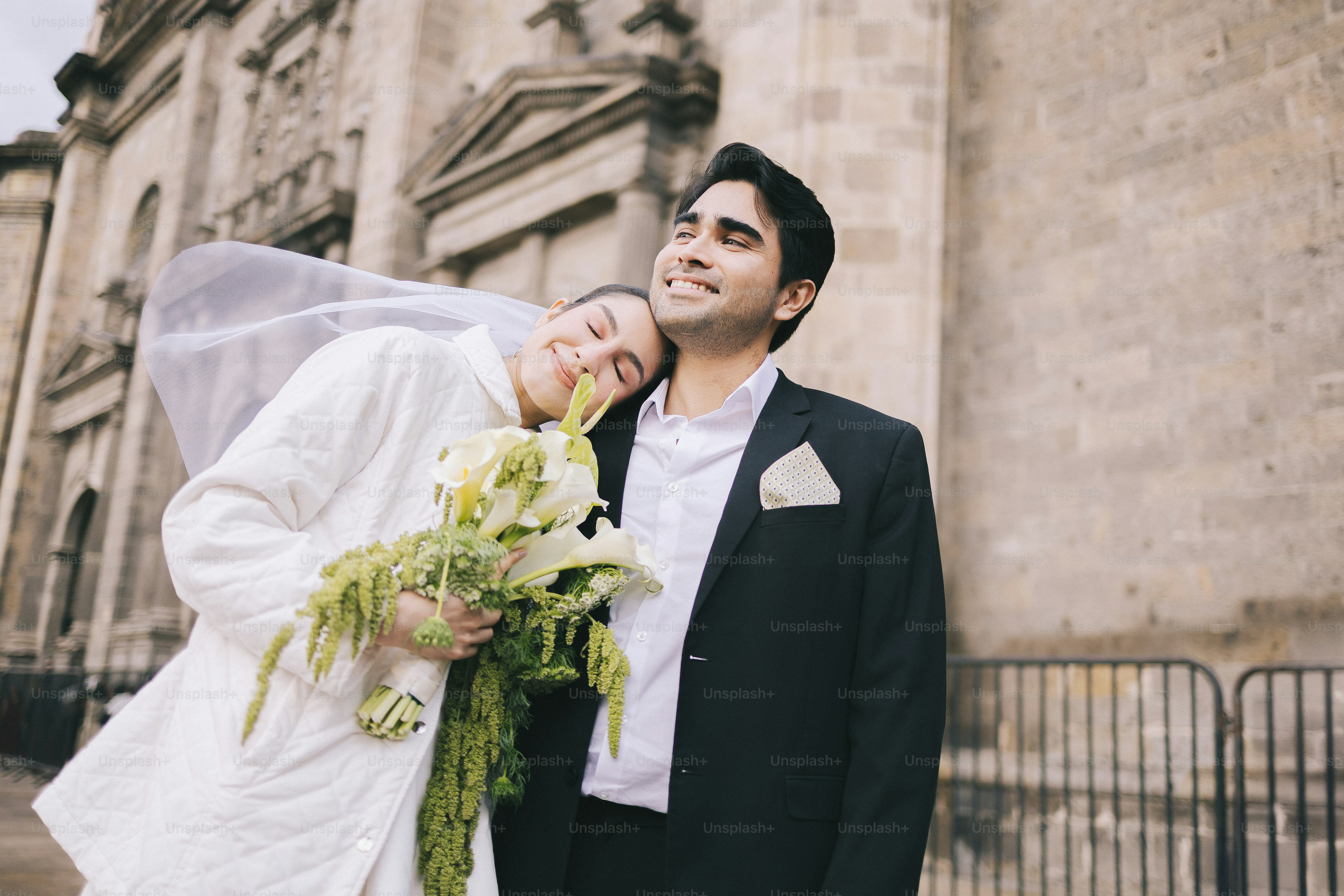 A smiling bride and groom outside a building photo – Couple Image on ...