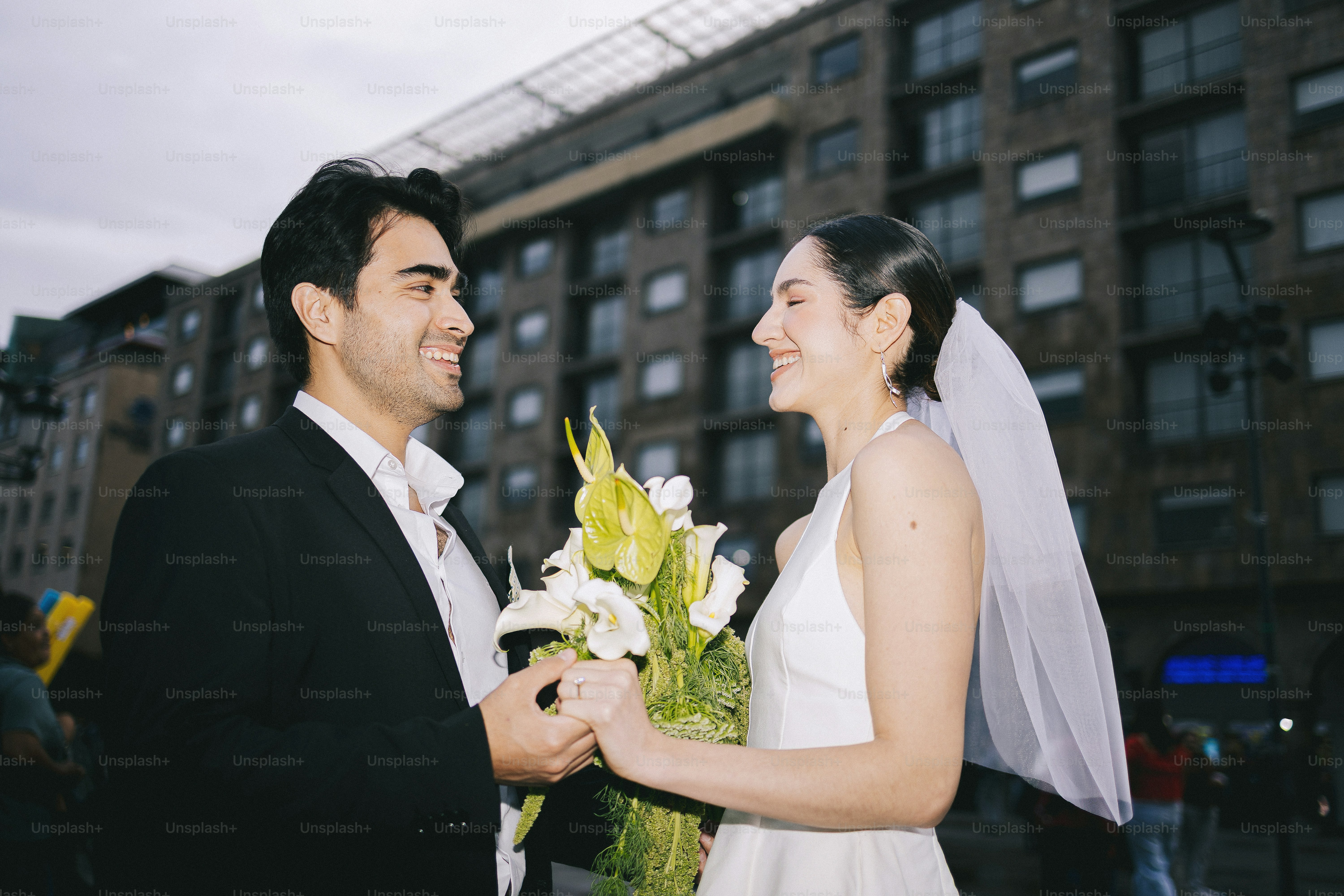 A smiling bride and groom hold hands with a bouquet. photo – Love Image ...