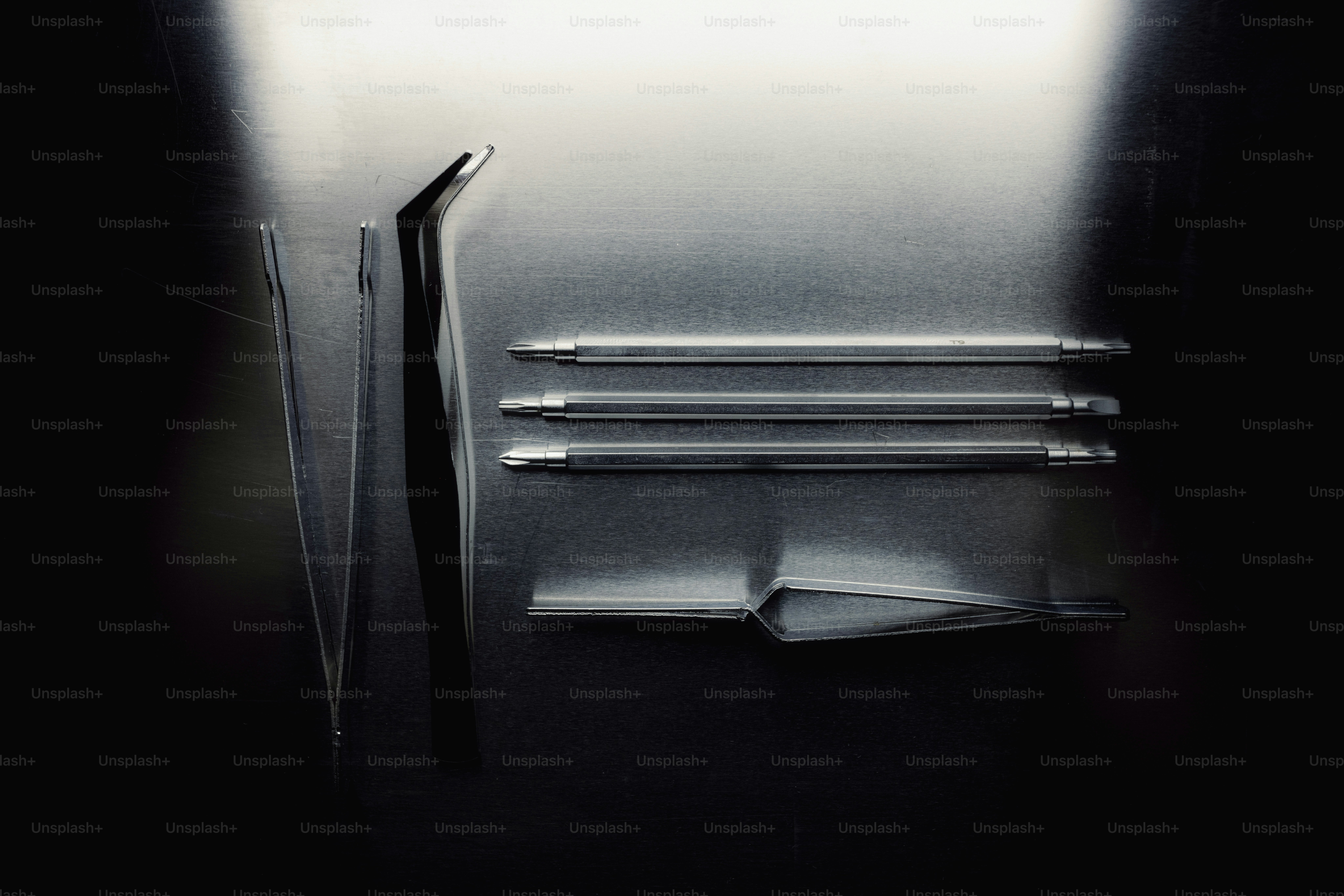 Instrumentos médicos, incluindo pinças e sondas sobre fundo escuro