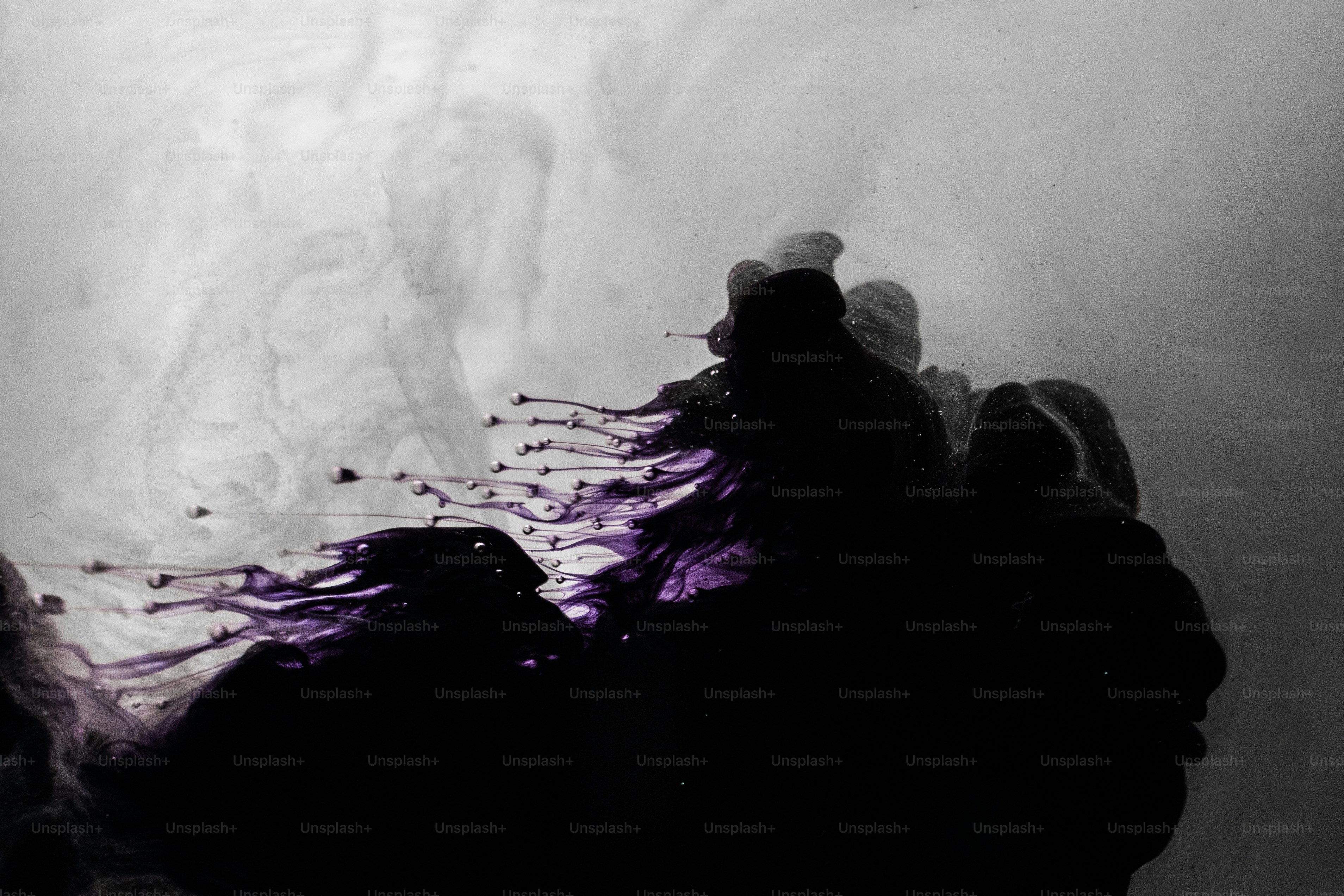 Tinta roxa e preta girando na água