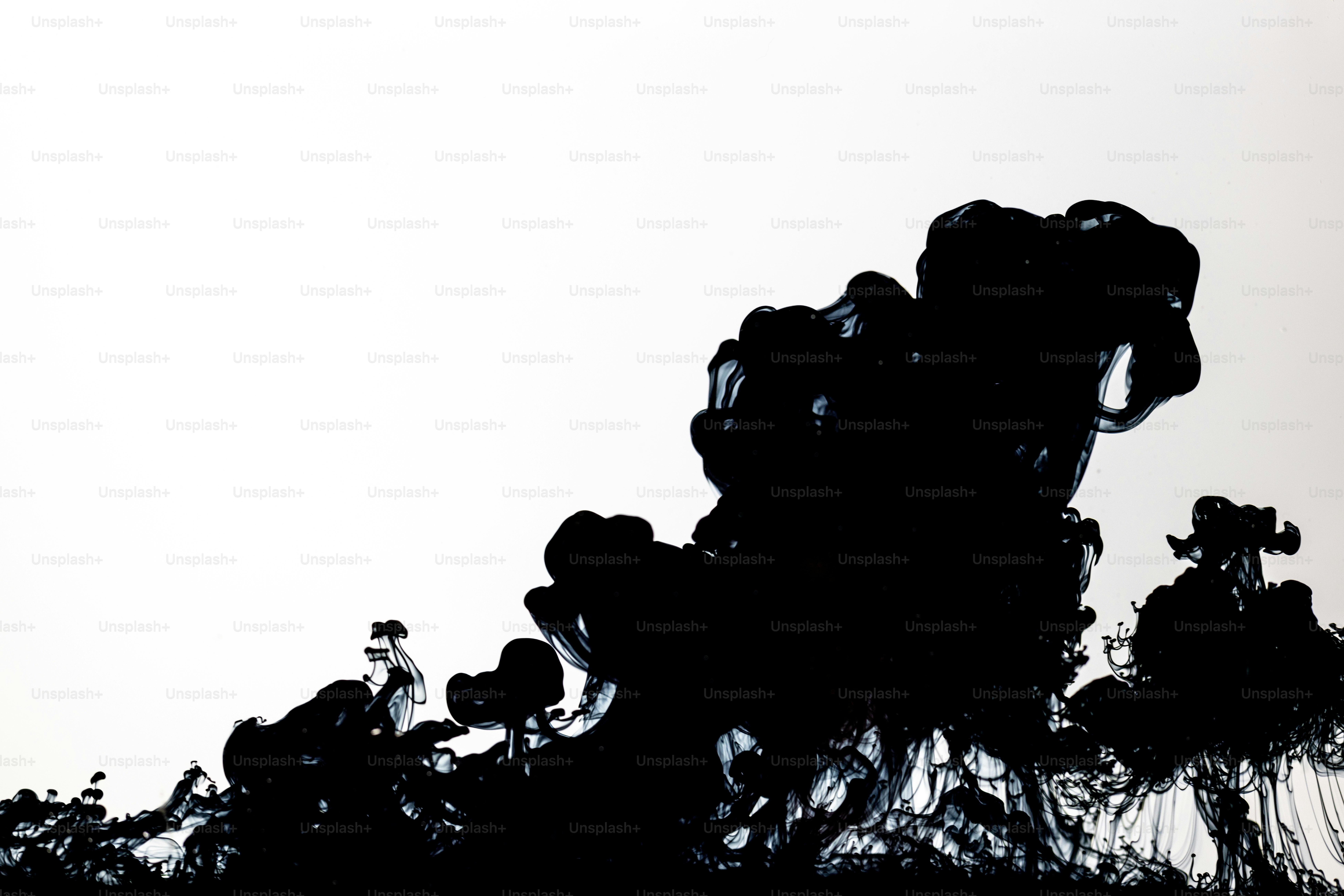 Encre noire qui se dissout dans l’eau claire, fond abstrait.
