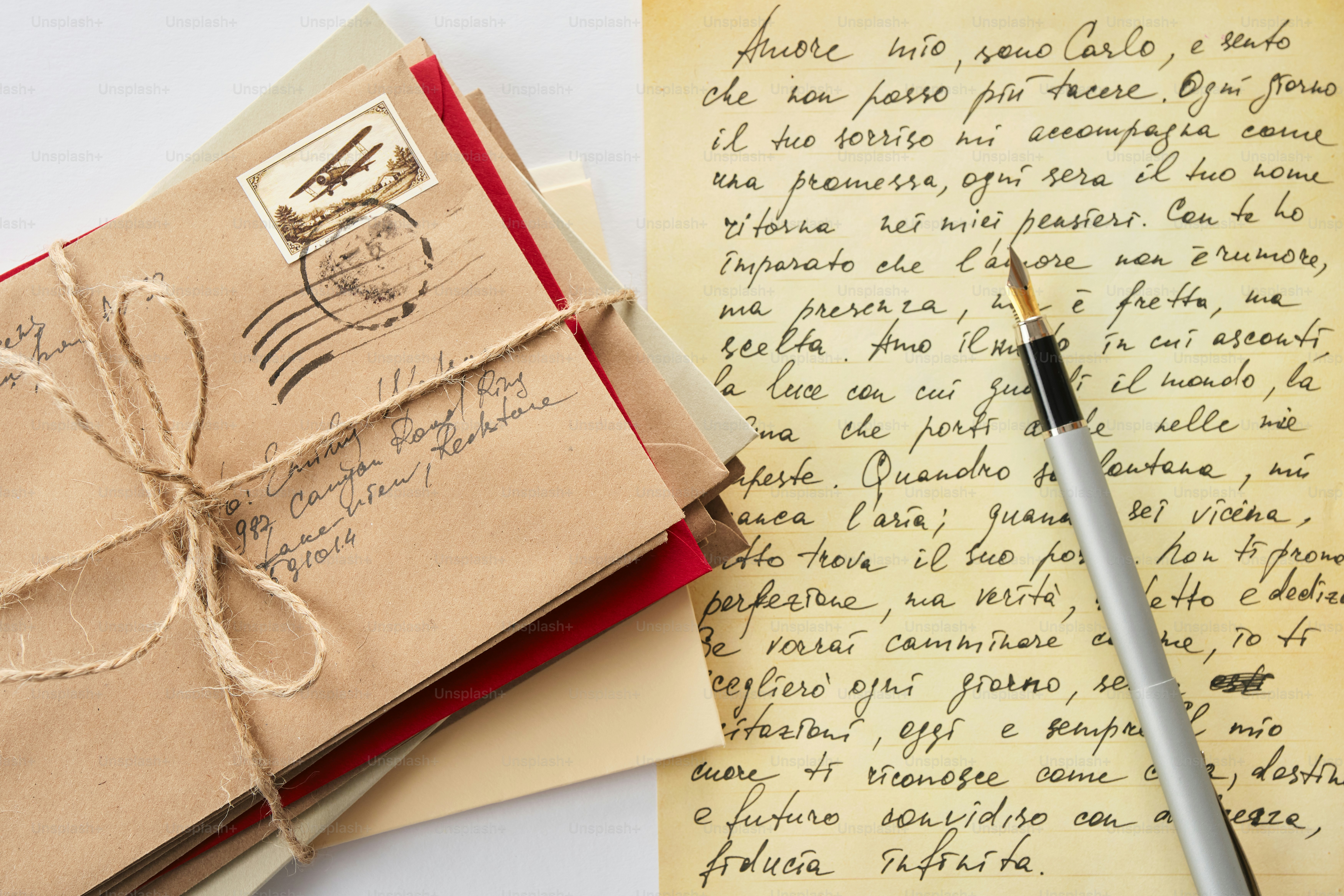 Pila di lettere legate con lo spago e una penna stilografica.