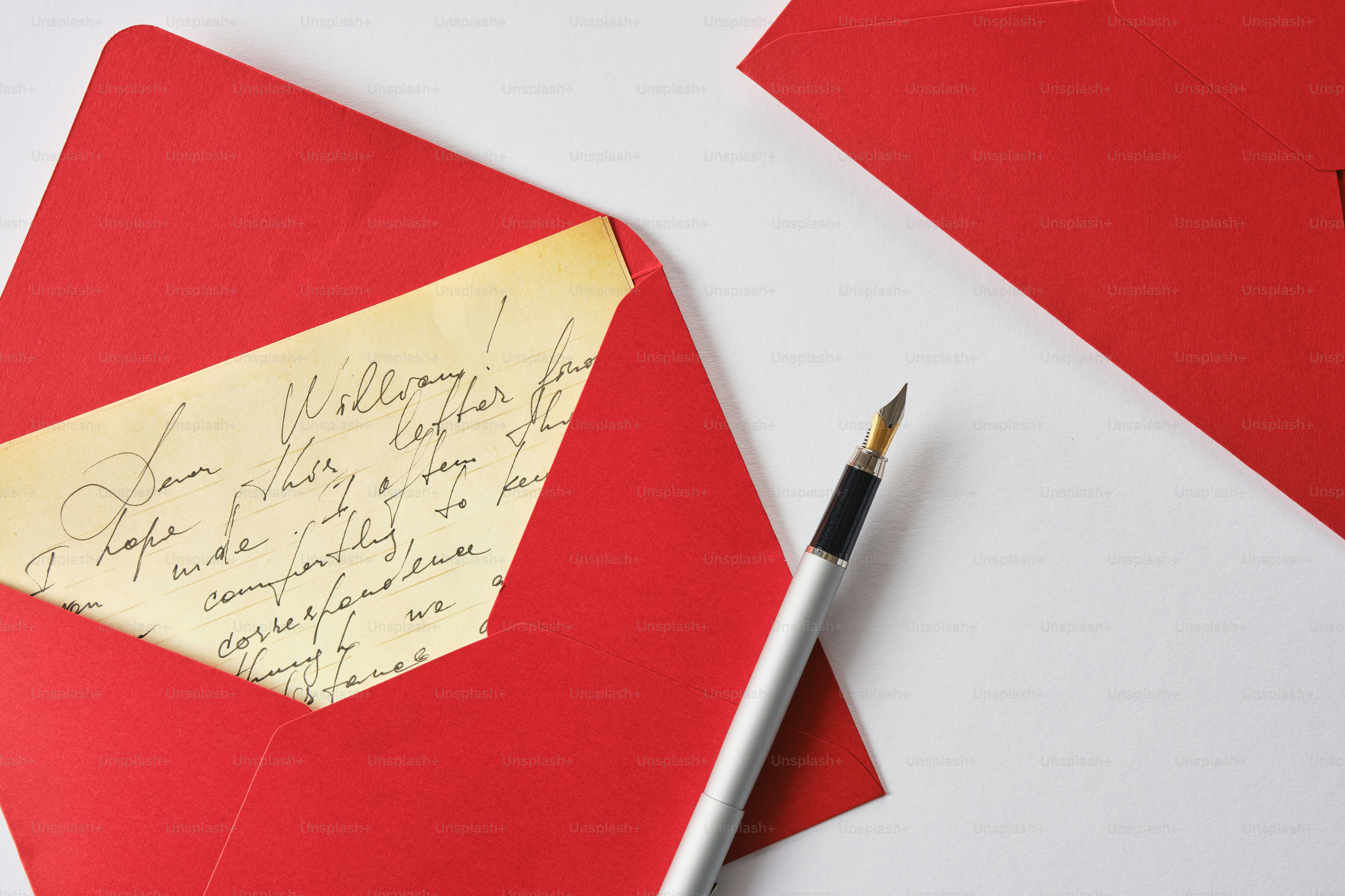 Una lettera e una penna su una busta rossa