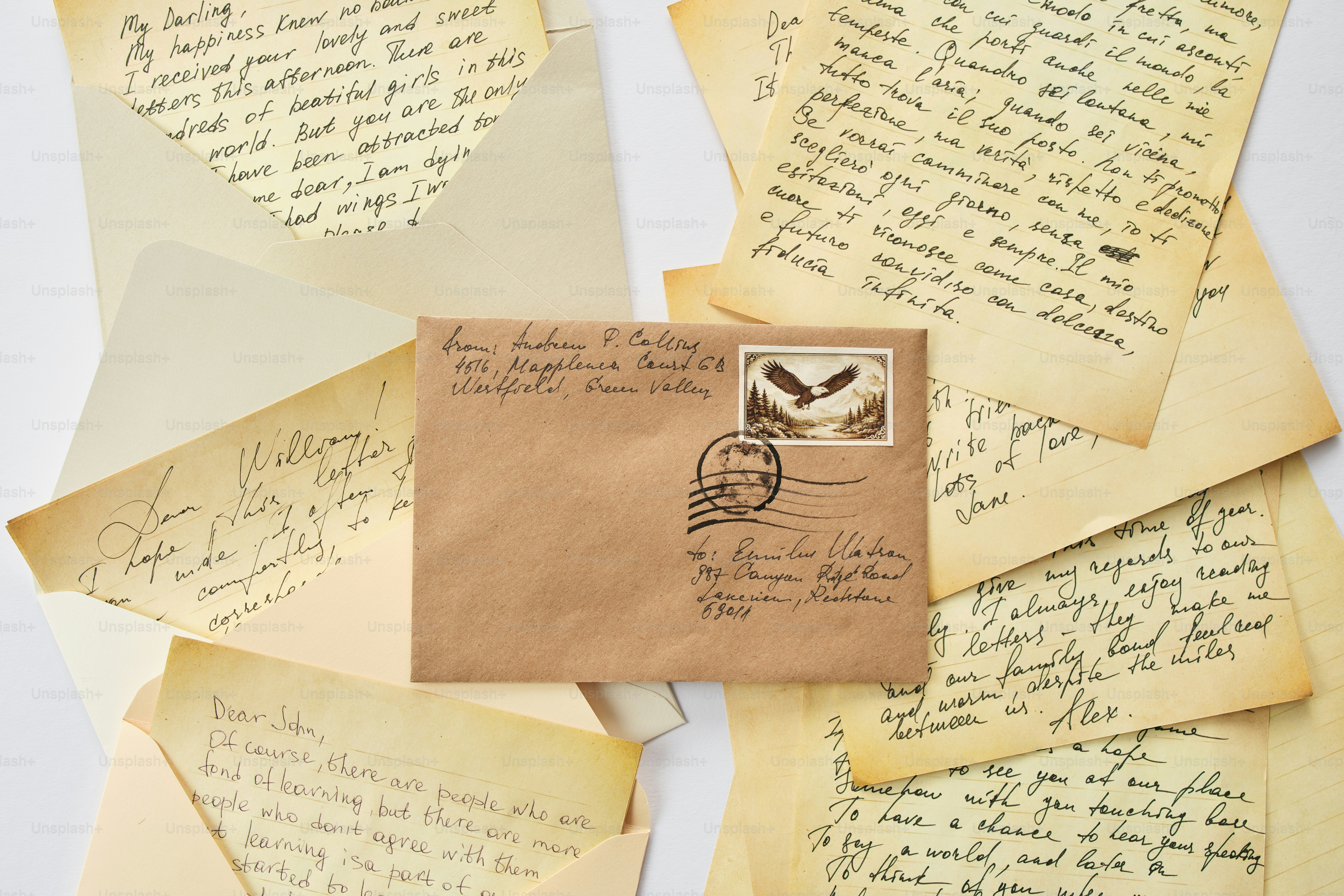 Brown envelope with letters and stamps on white background