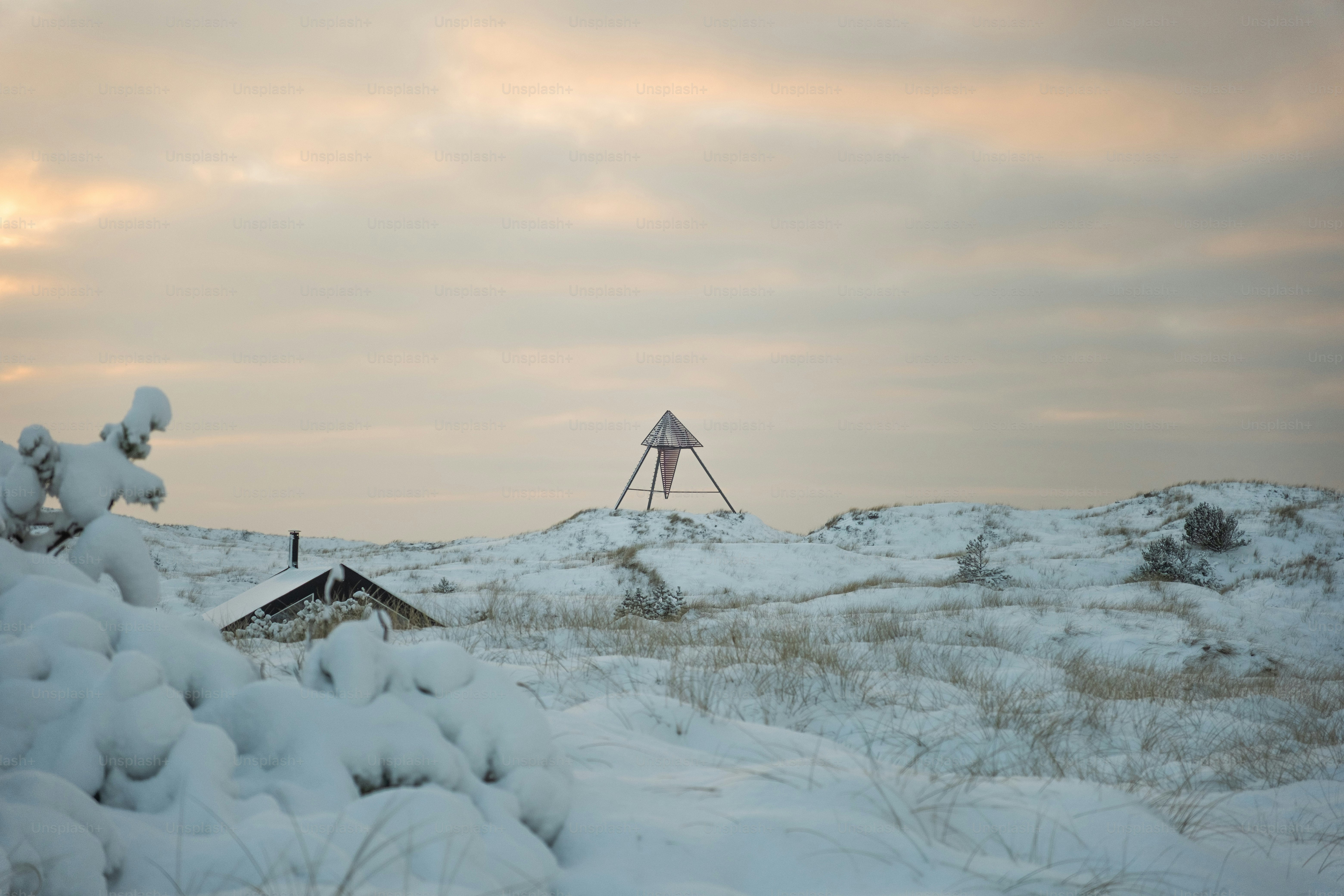 Paysage enneigé avec une petite cabane et une tour d’observation.