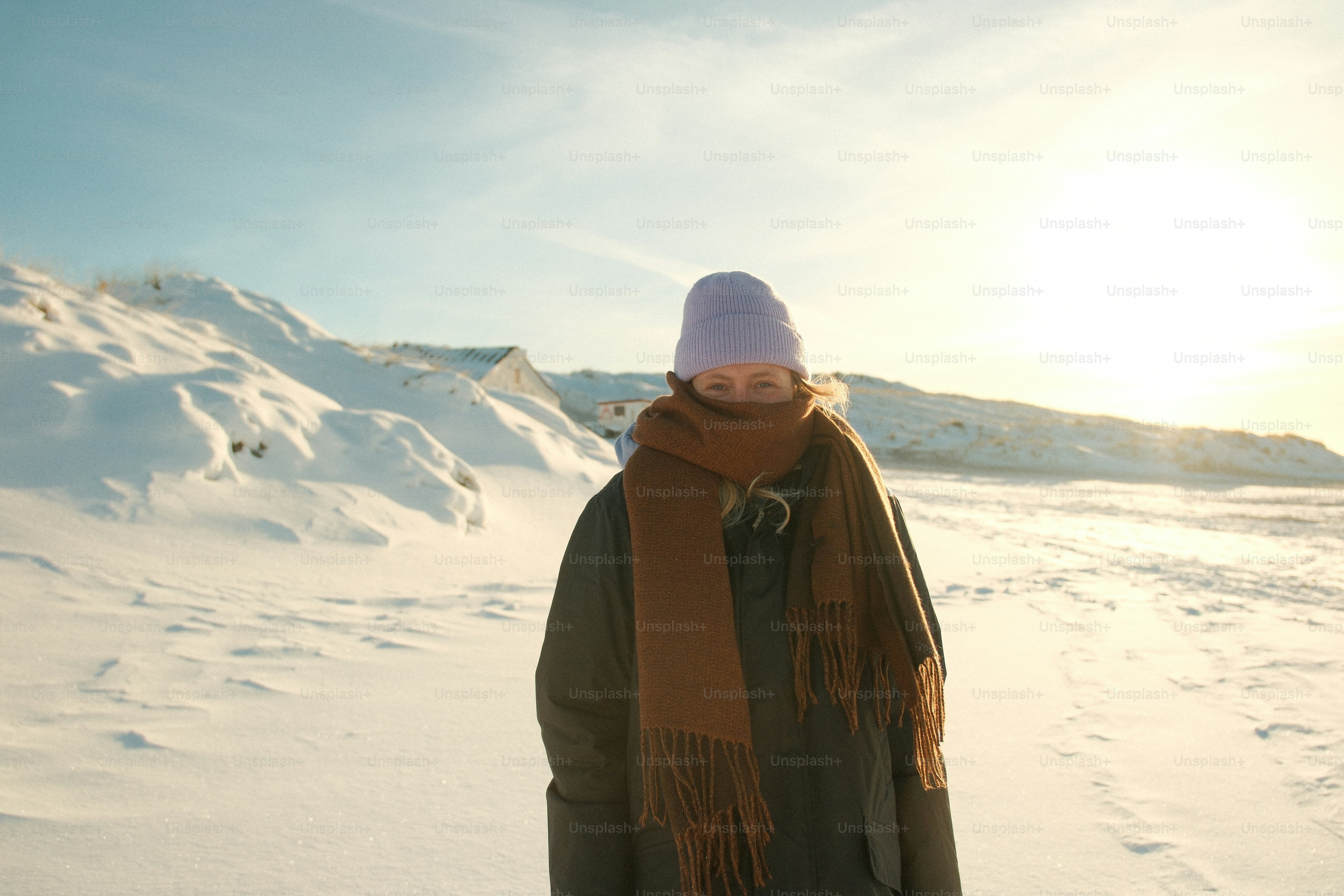 Personne emmitouflée dans des vêtements chauds dans un paysage enneigé.