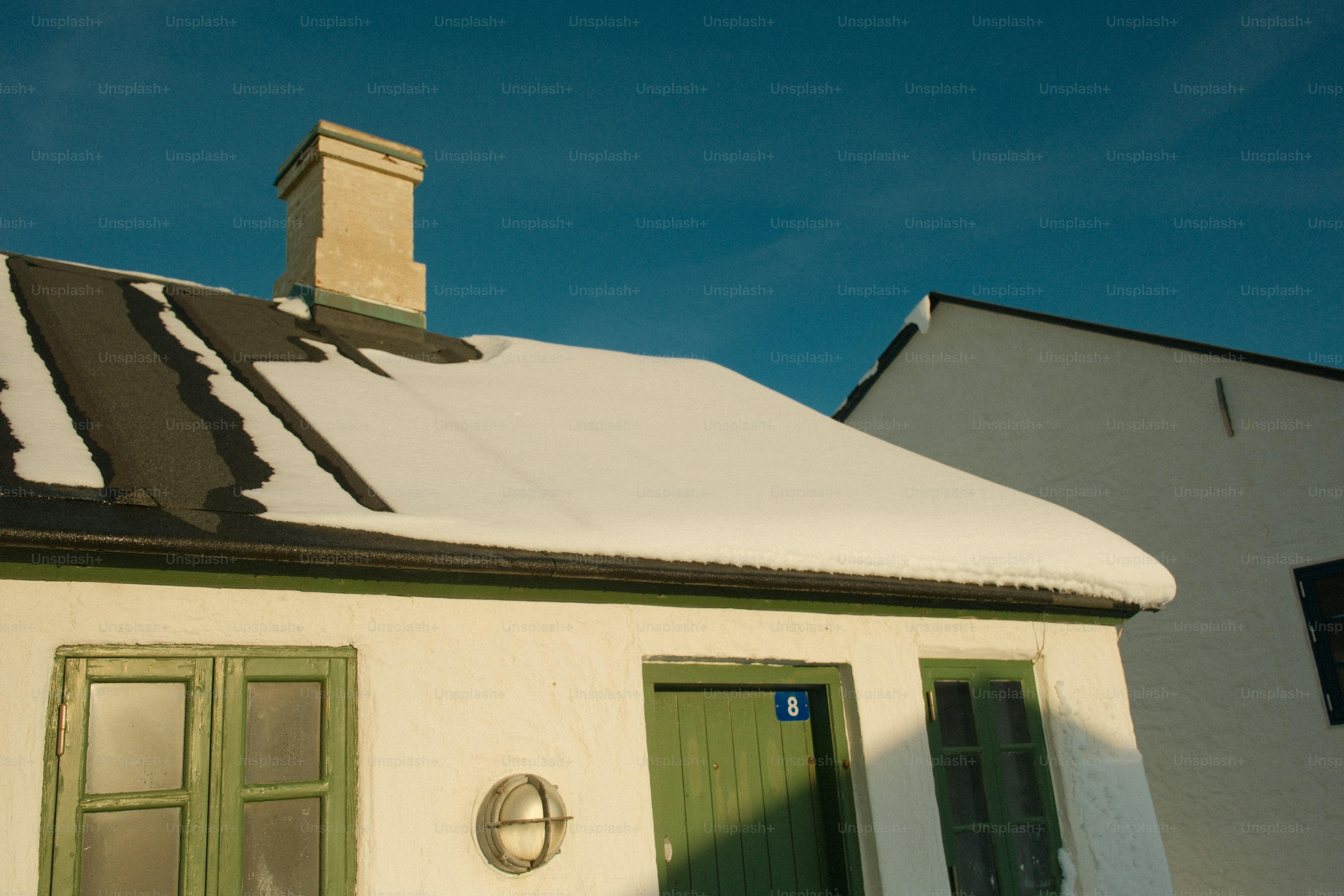 White house with snow on the roof and blue sky
