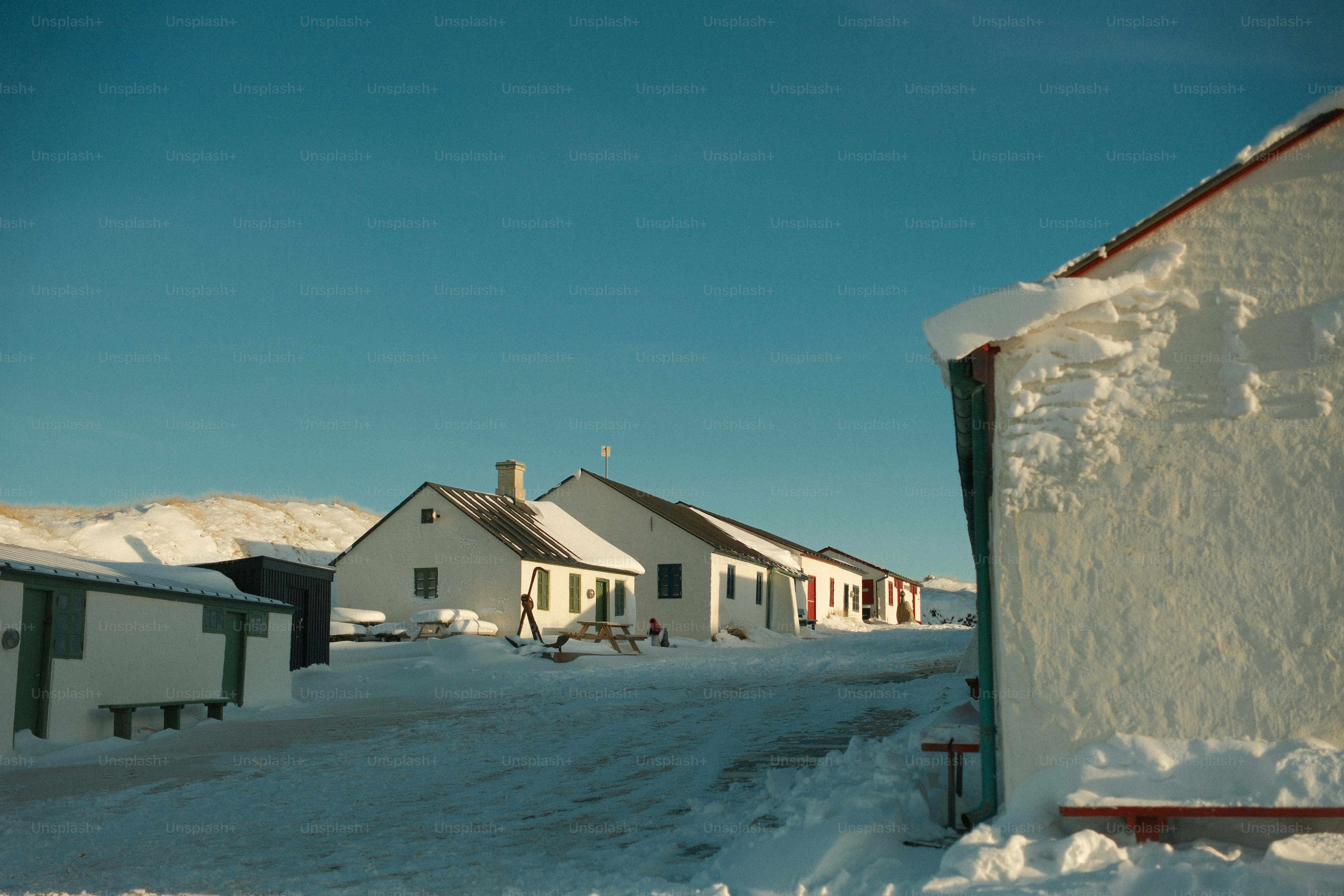 Snow-covered buildings under a clear blue sky