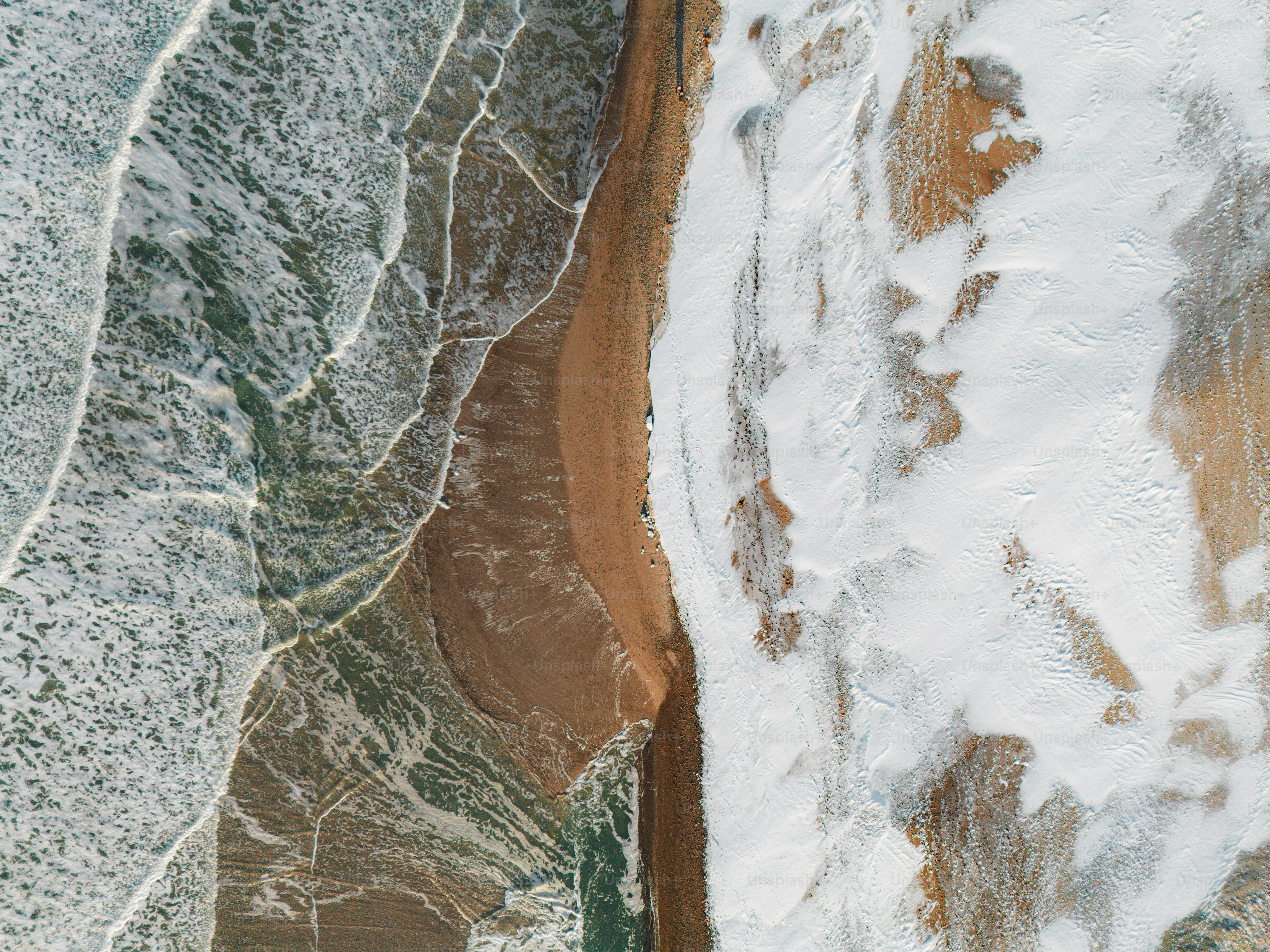 Vue aérienne des vagues de l’océan s’écrasant sur une plage de sable