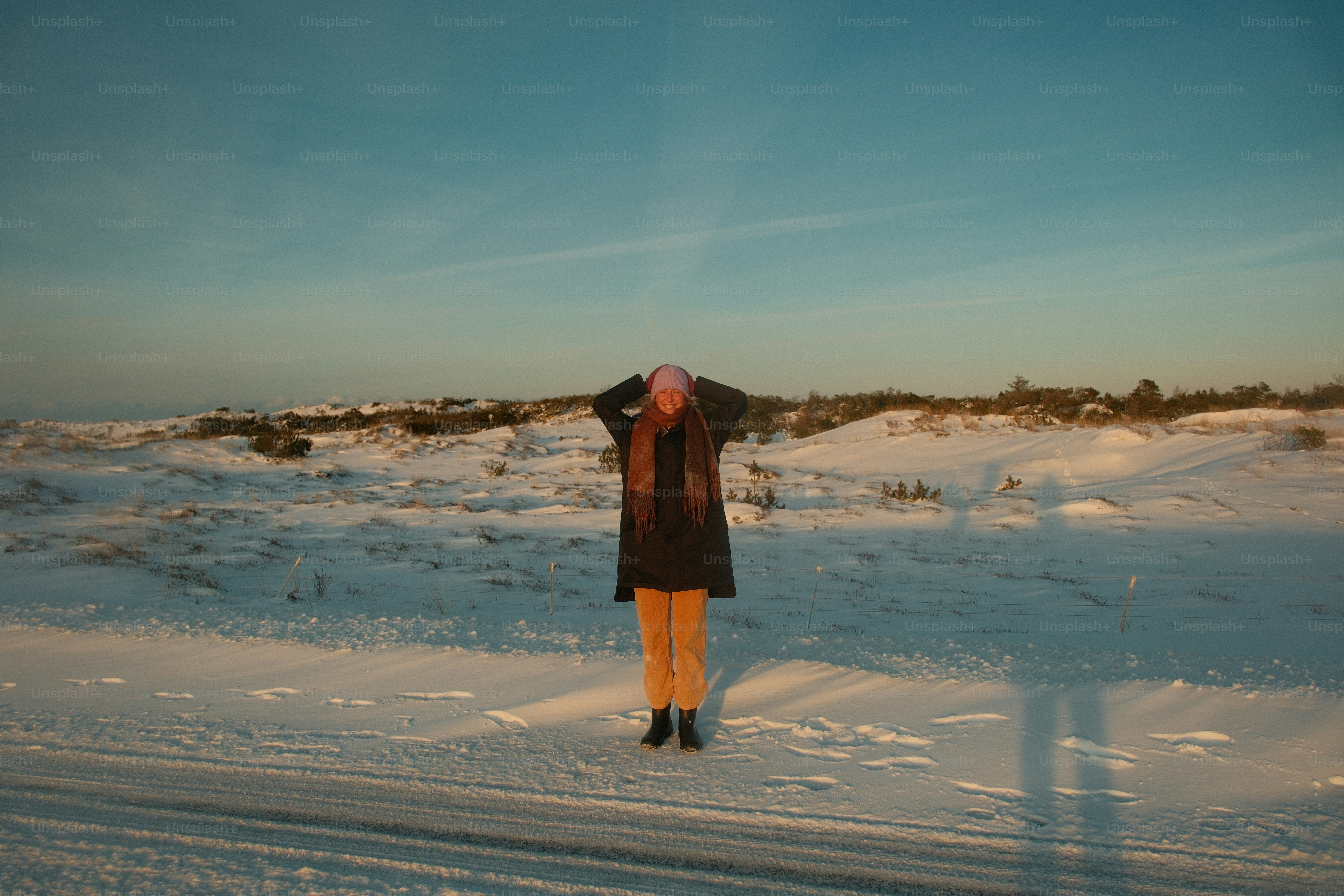 Femme en vêtements d’hiver debout dans un paysage enneigé